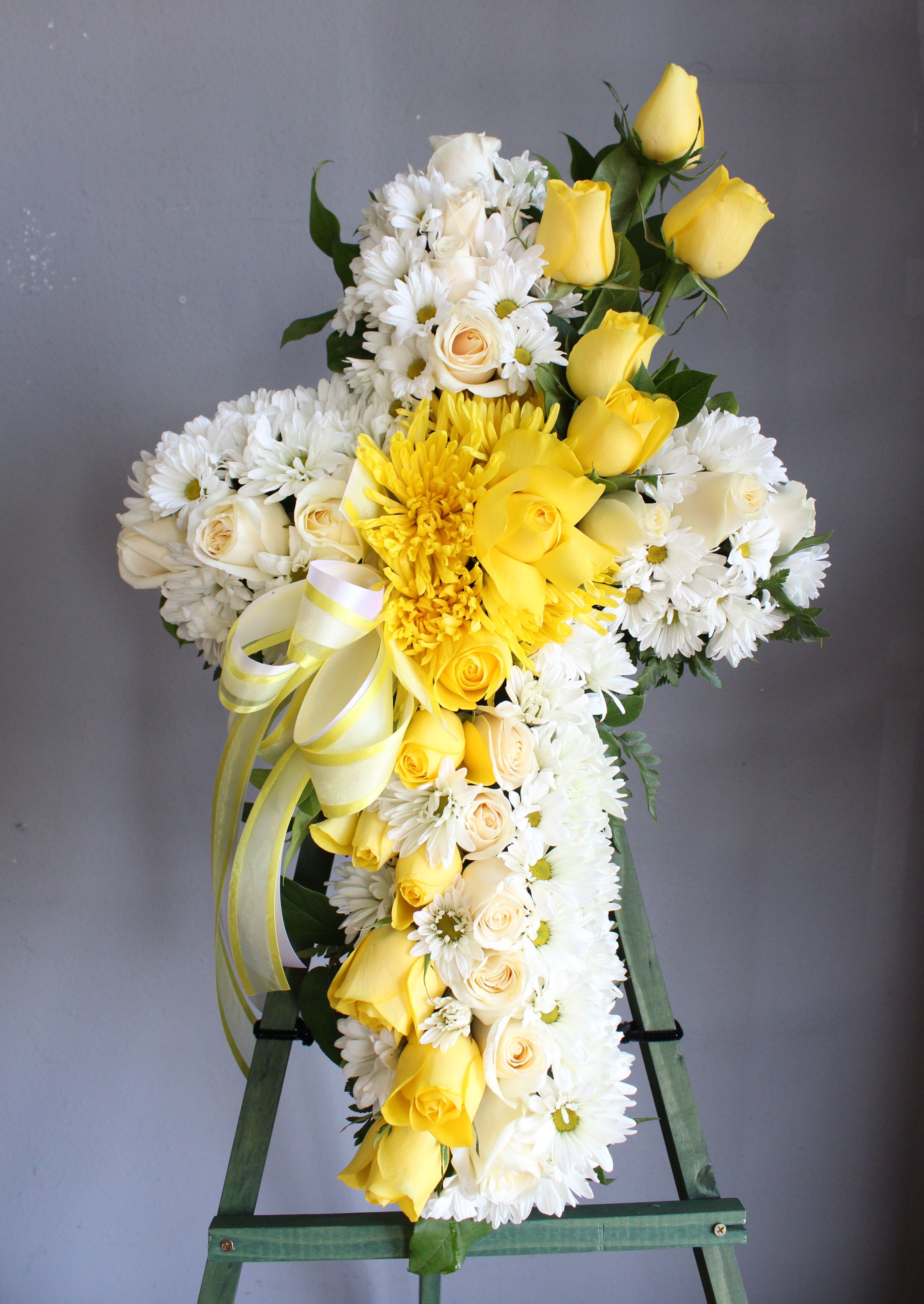 Yellow and white floral standing spray on an easel