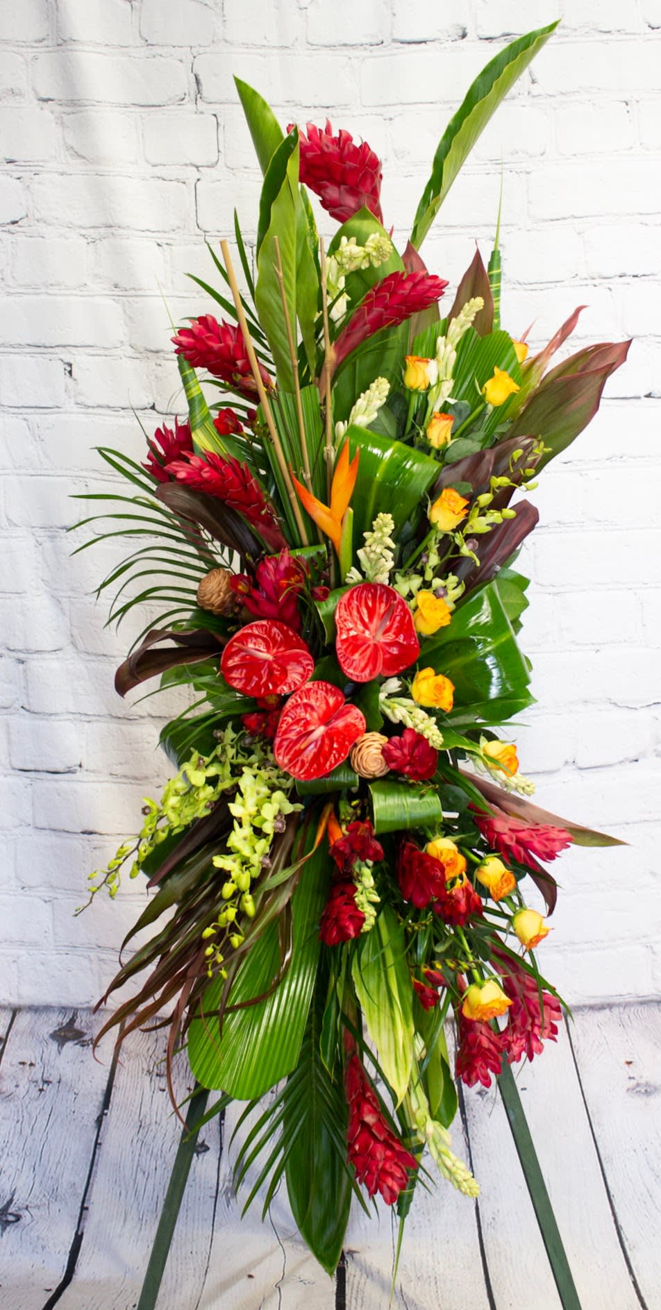 Tall tropical floral spray with red and yellow blooms on a stand