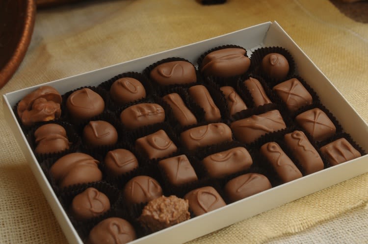 Box of assorted chocolate candies in paper cups