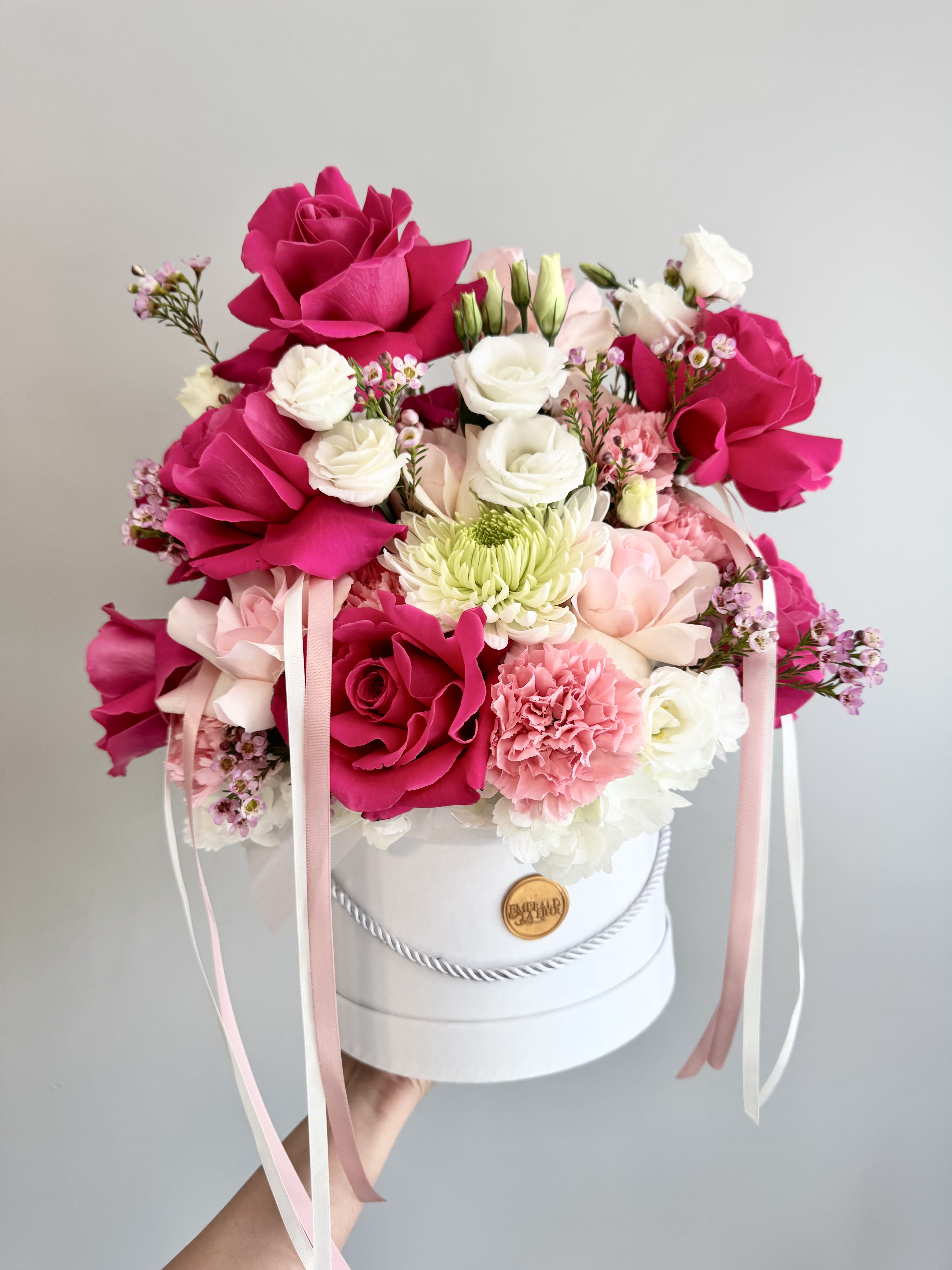 Pink and white rose bouquet in a white hat box with ribbons