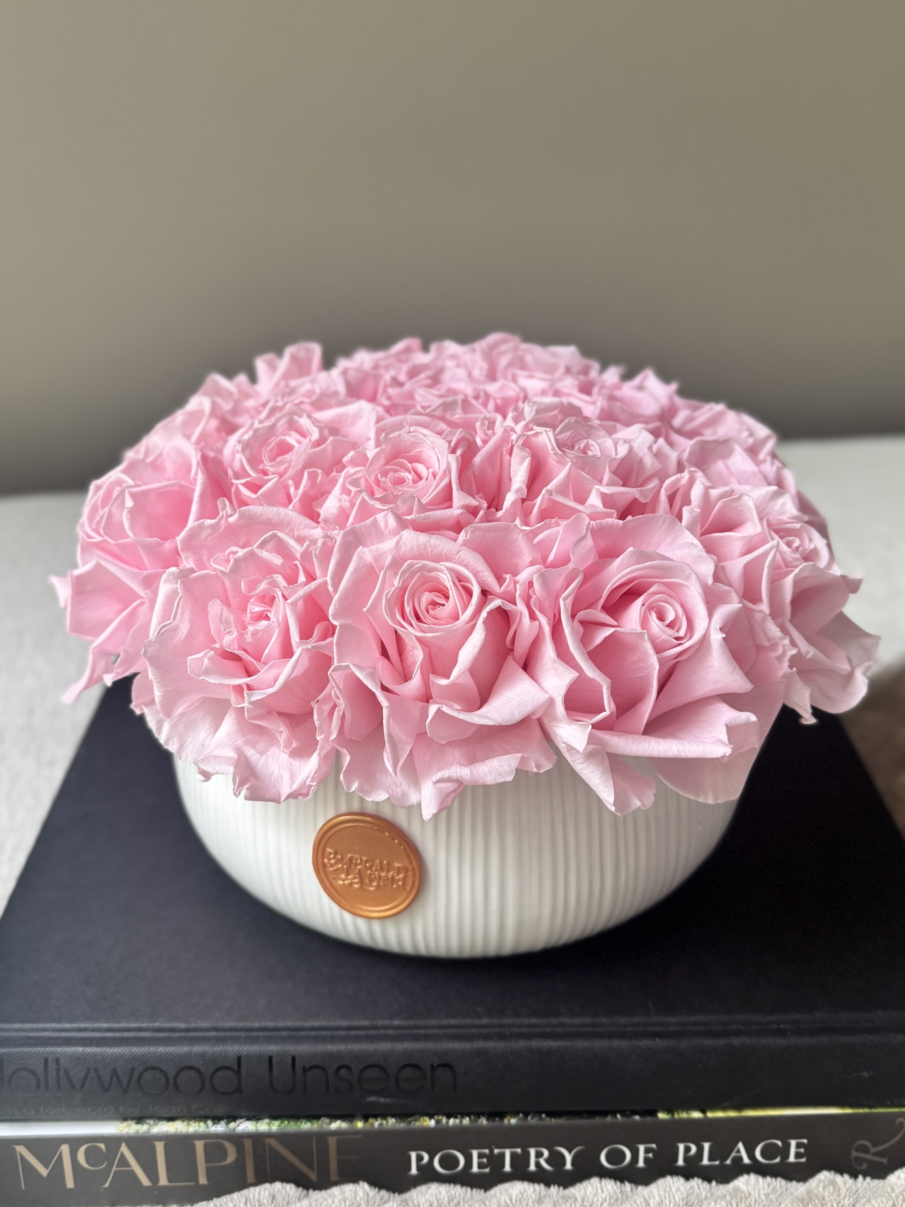 Pink rose arrangement in a white ribbed bowl