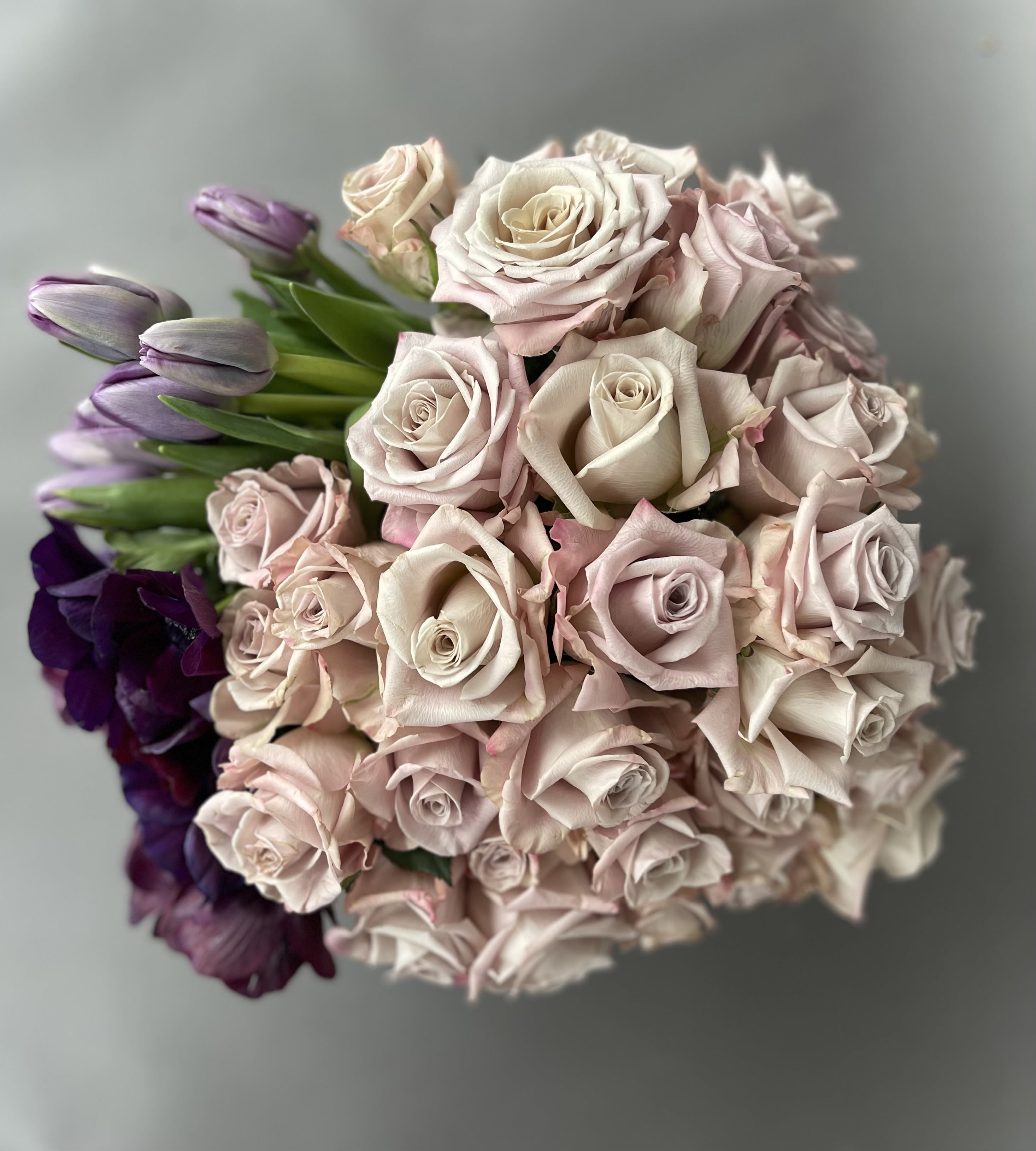Bouquet of pale pink roses with purple tulips