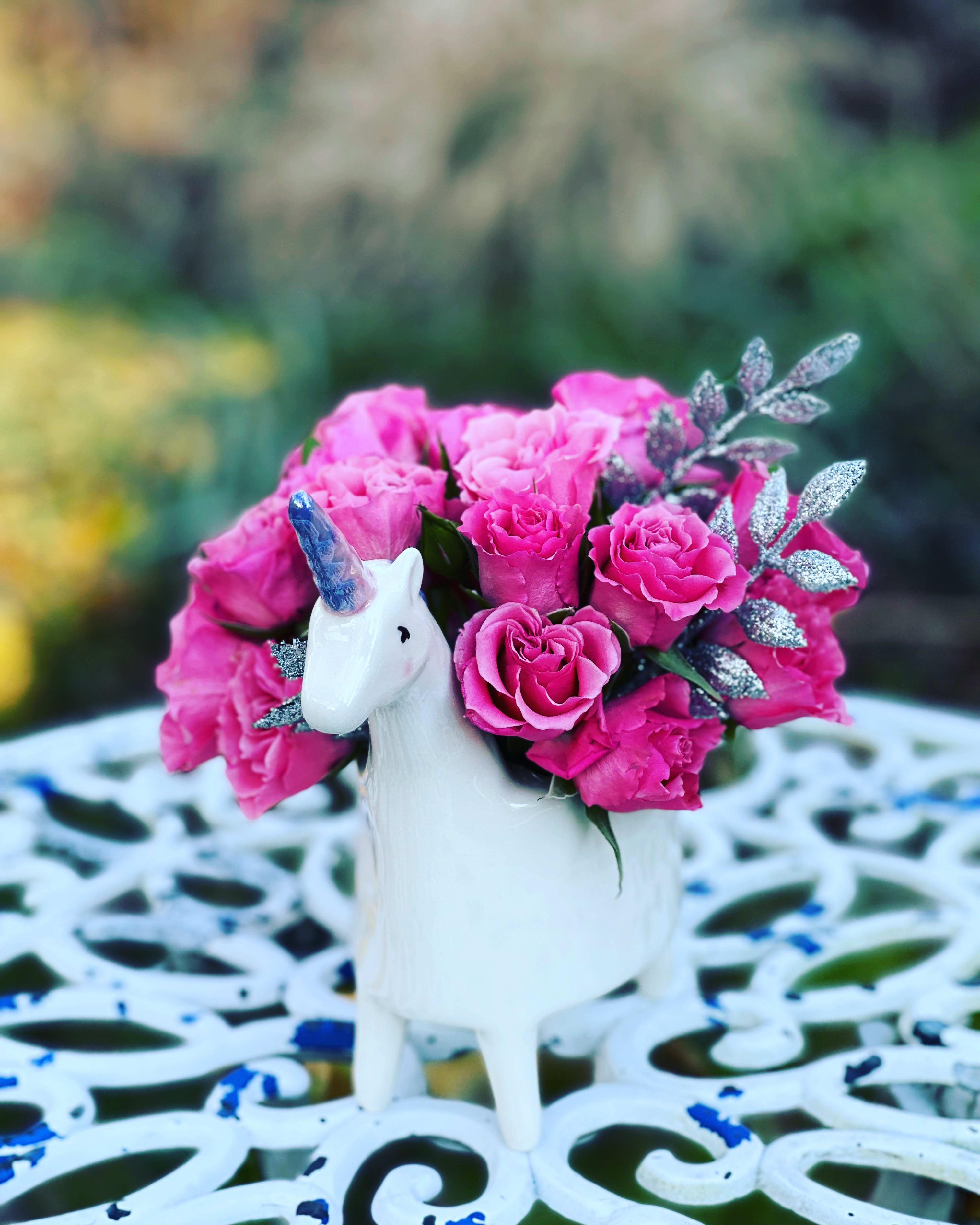 Pink rose bouquet in a white unicorn vase
