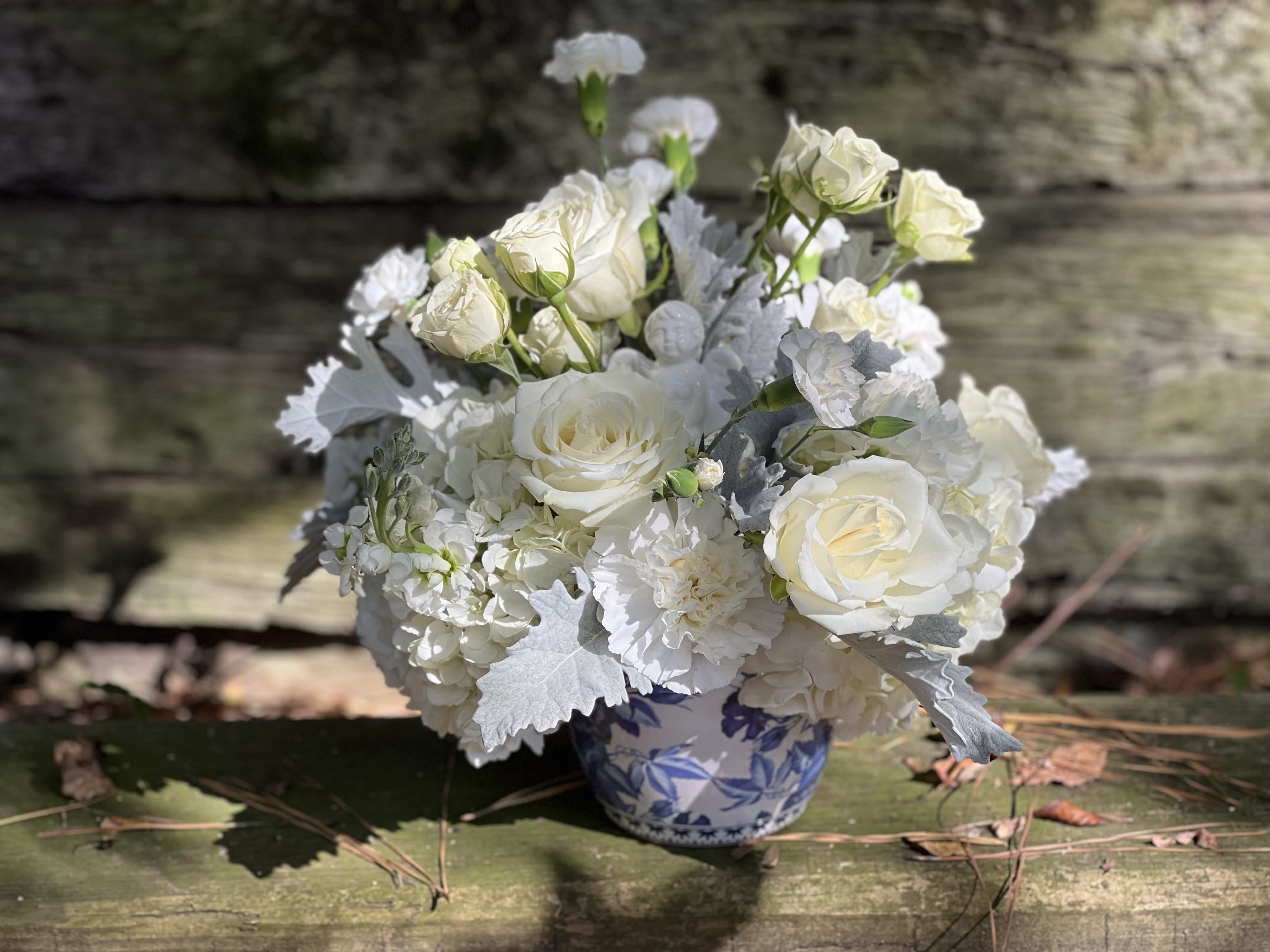 White rose bouquet in a blue-and-white ceramic vase