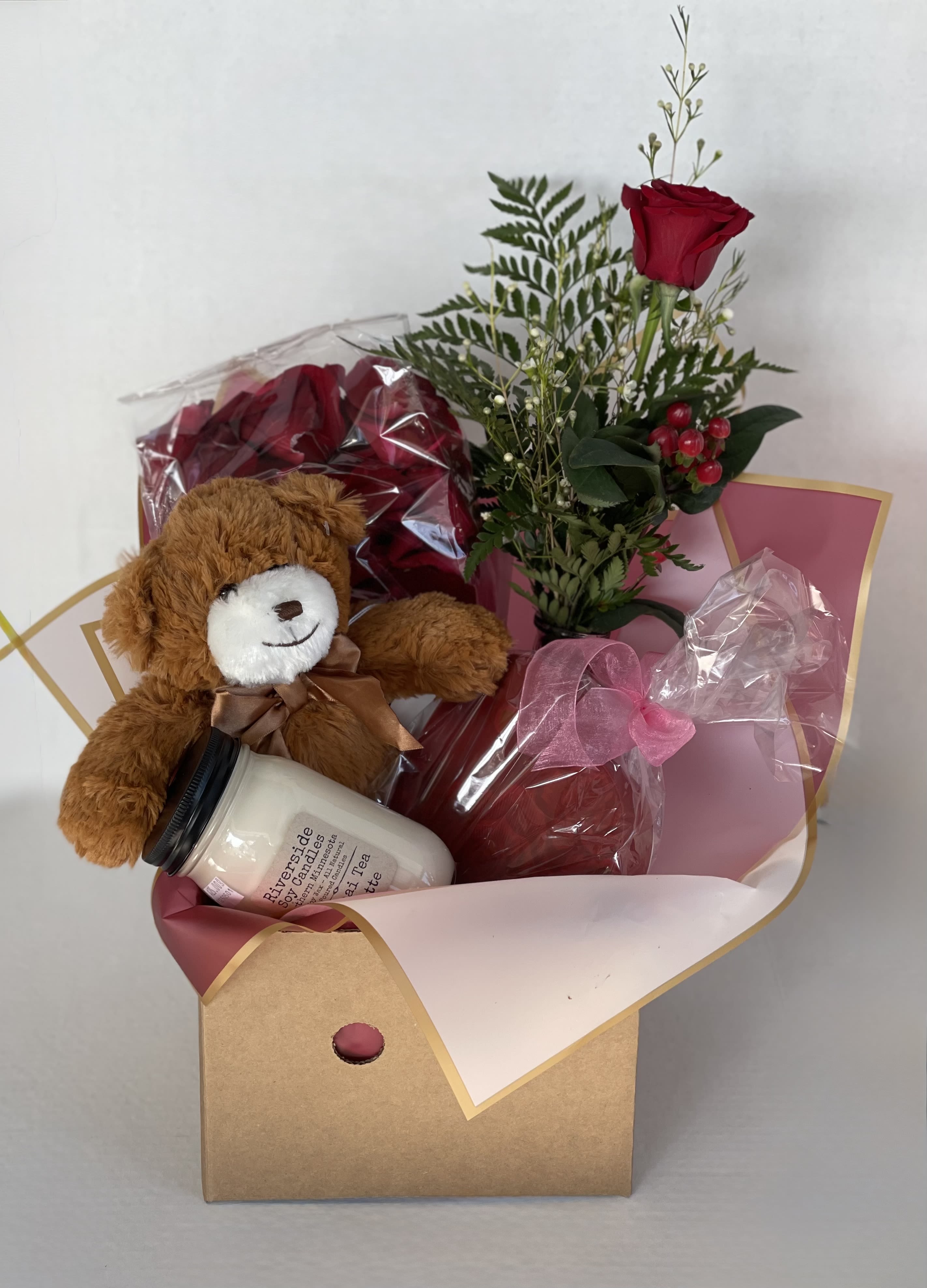 Gift box with a teddy bear, candle, and red rose bouquet