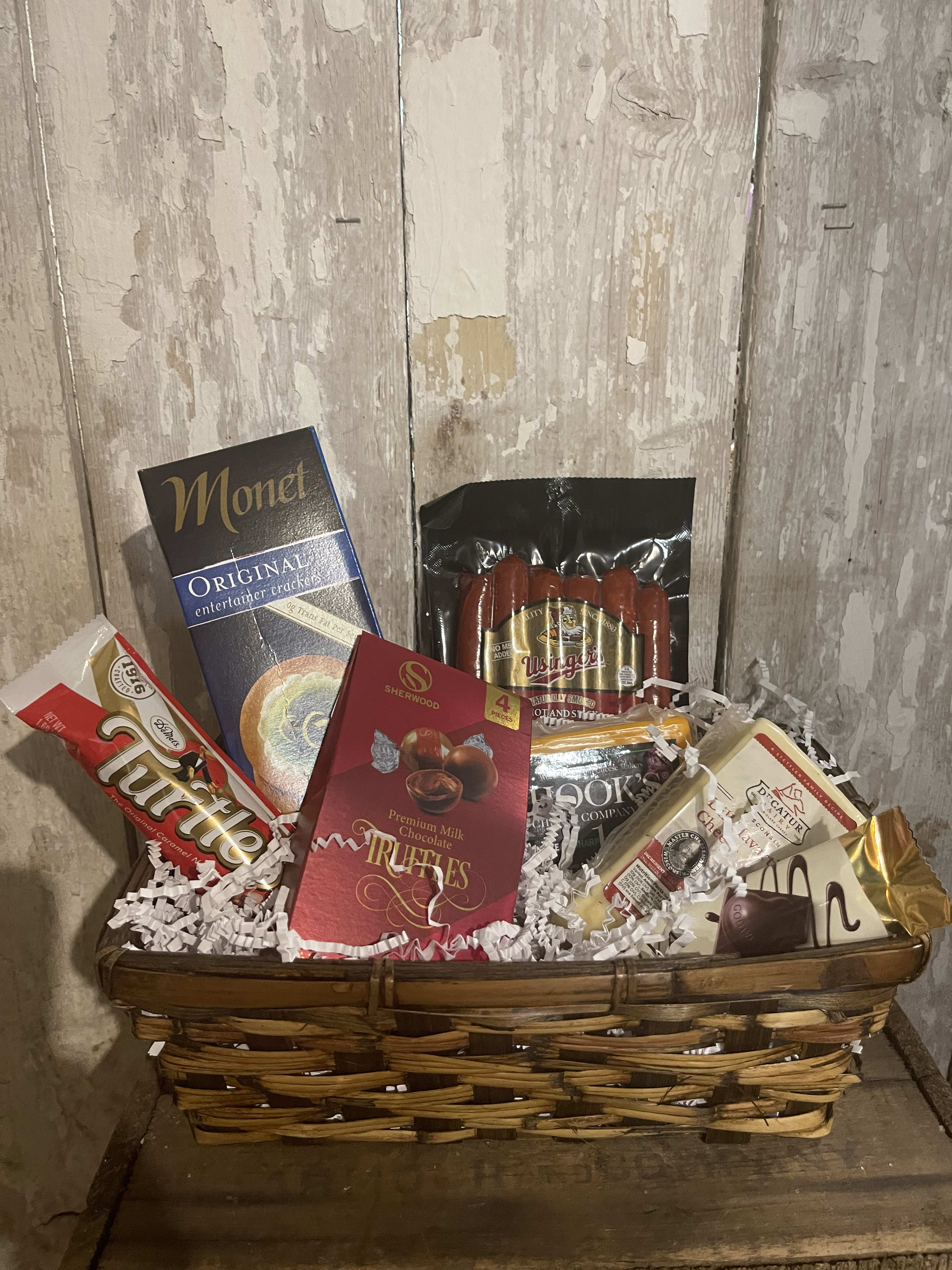 Gift basket with assorted chocolates and packaged snacks in a wicker basket