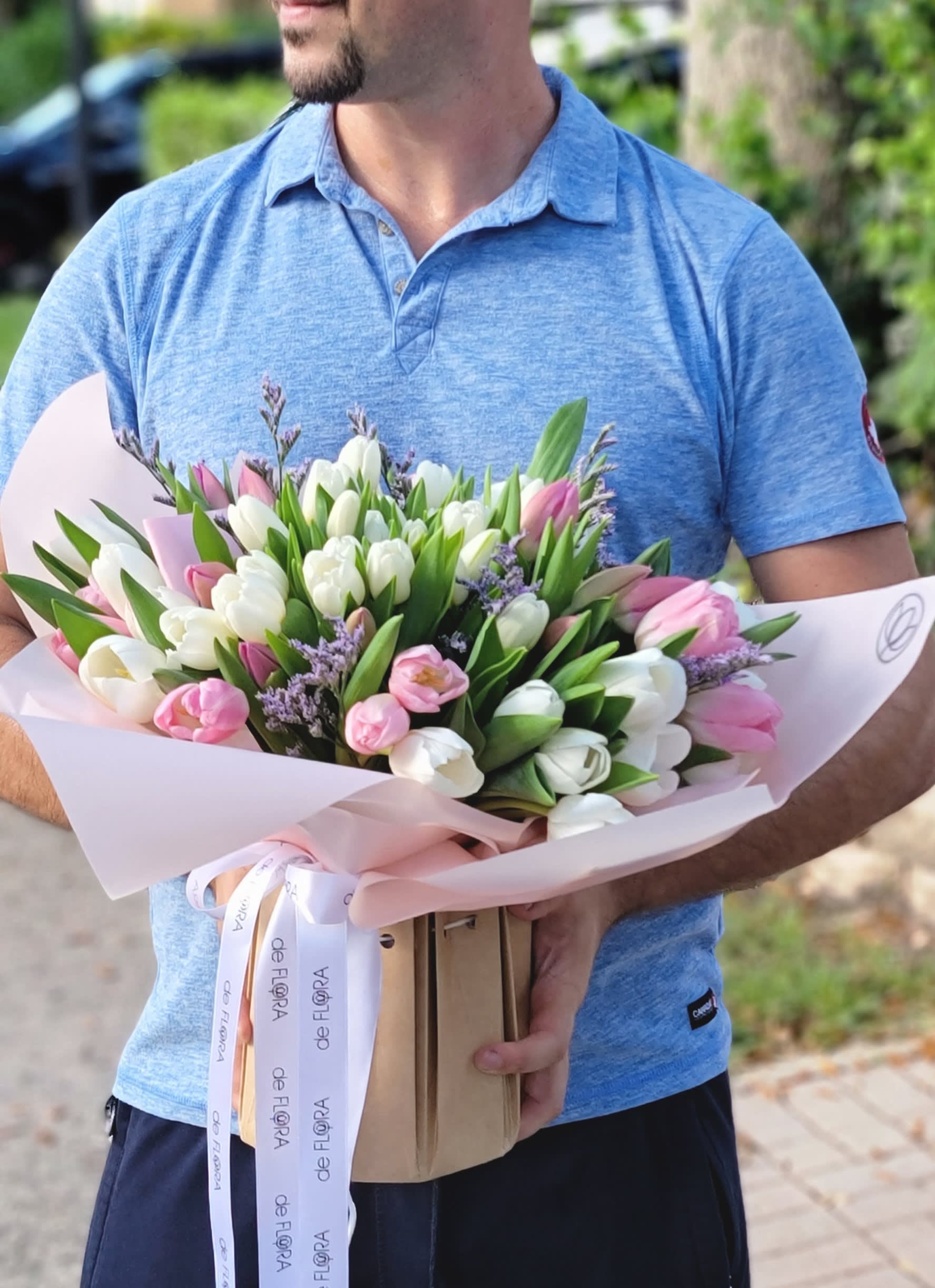 Bouquet of pink and white tulips wrapped in pale pink paper