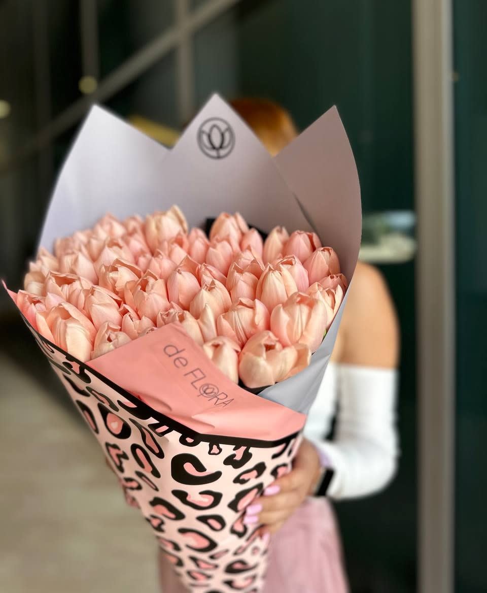 Bouquet of pale pink tulips wrapped in patterned paper