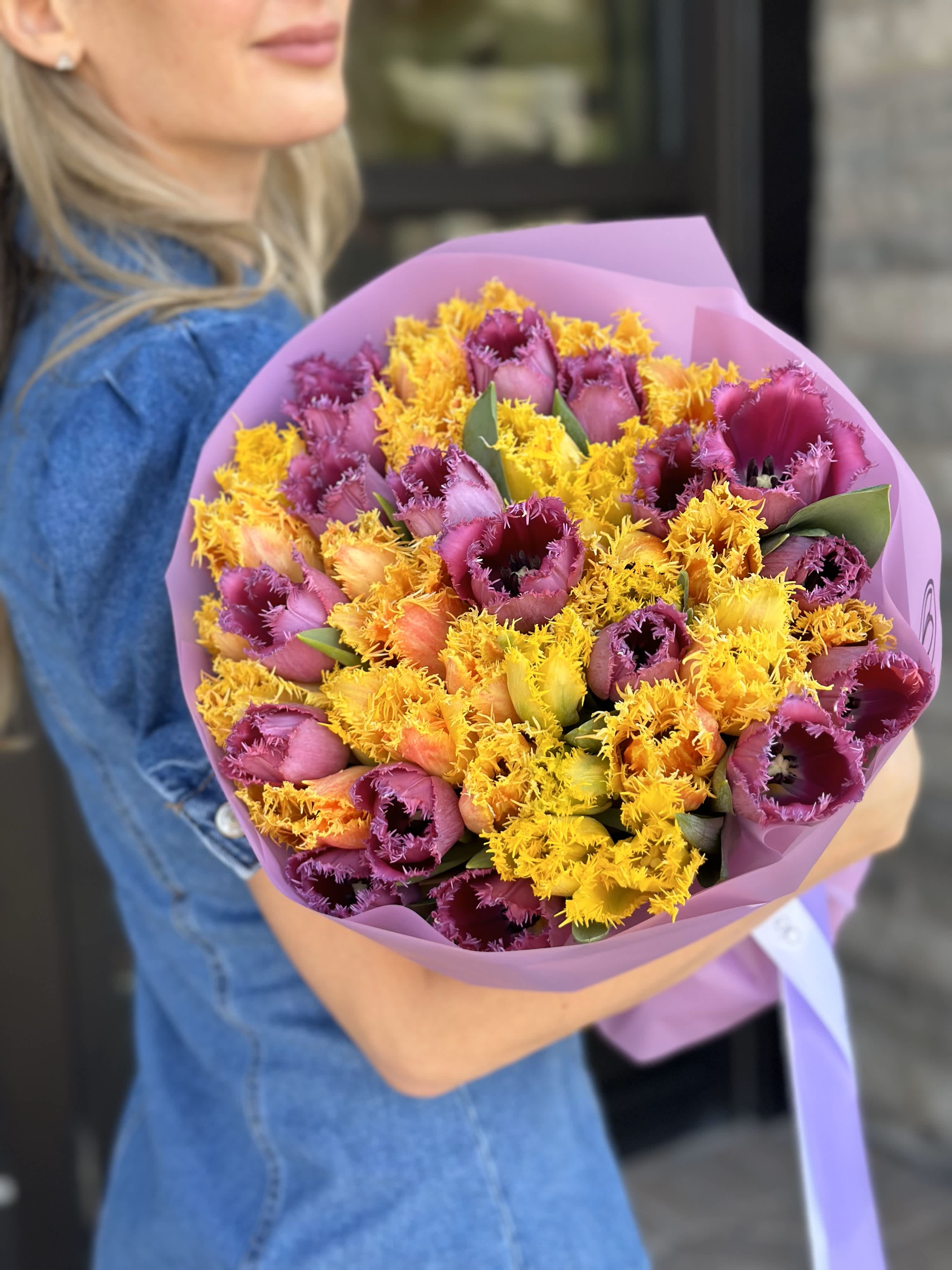 Bouquet of purple and yellow fringed tulips wrapped in pink paper