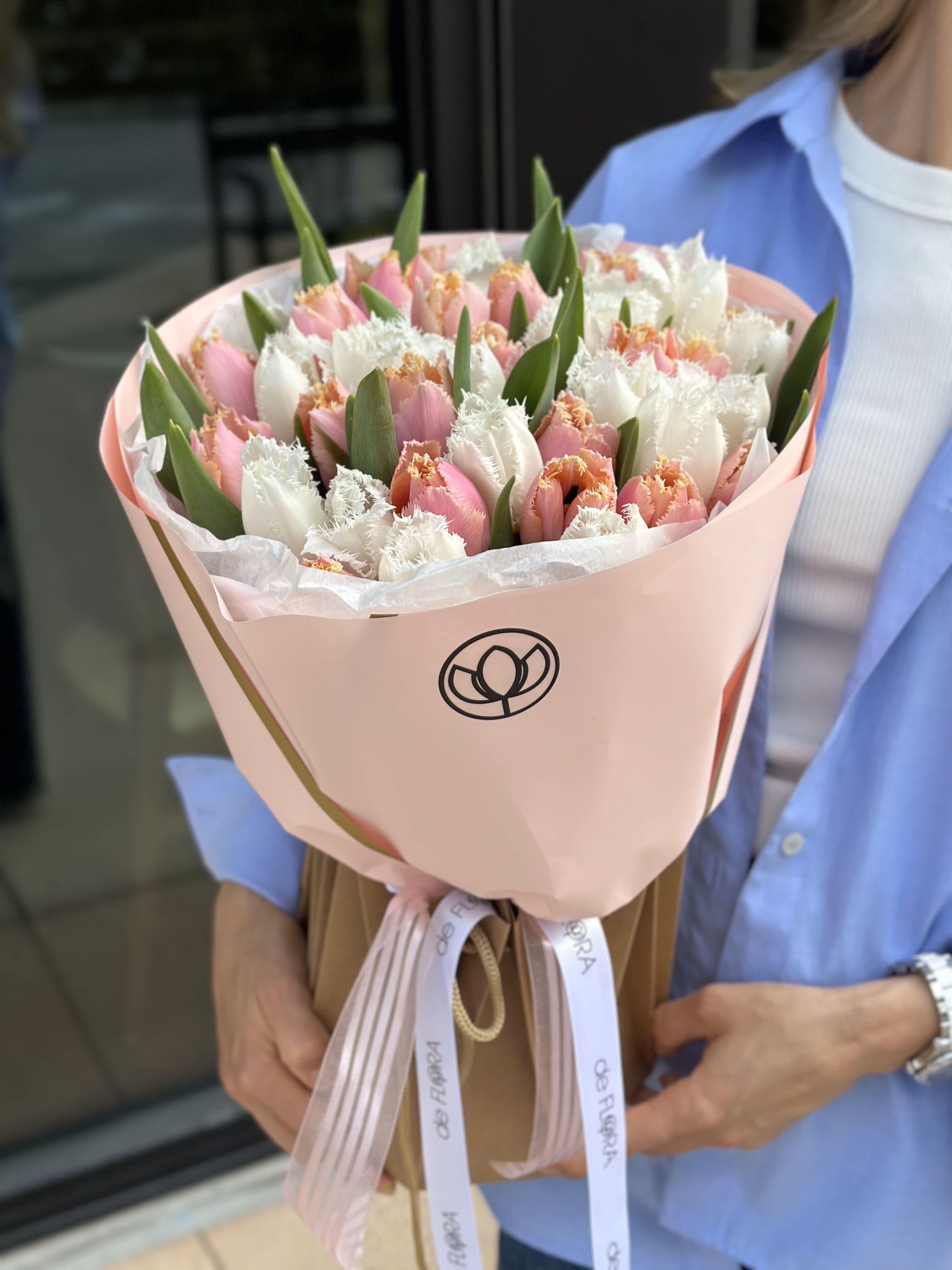 Bouquet of pink and white tulips wrapped in pale pink paper