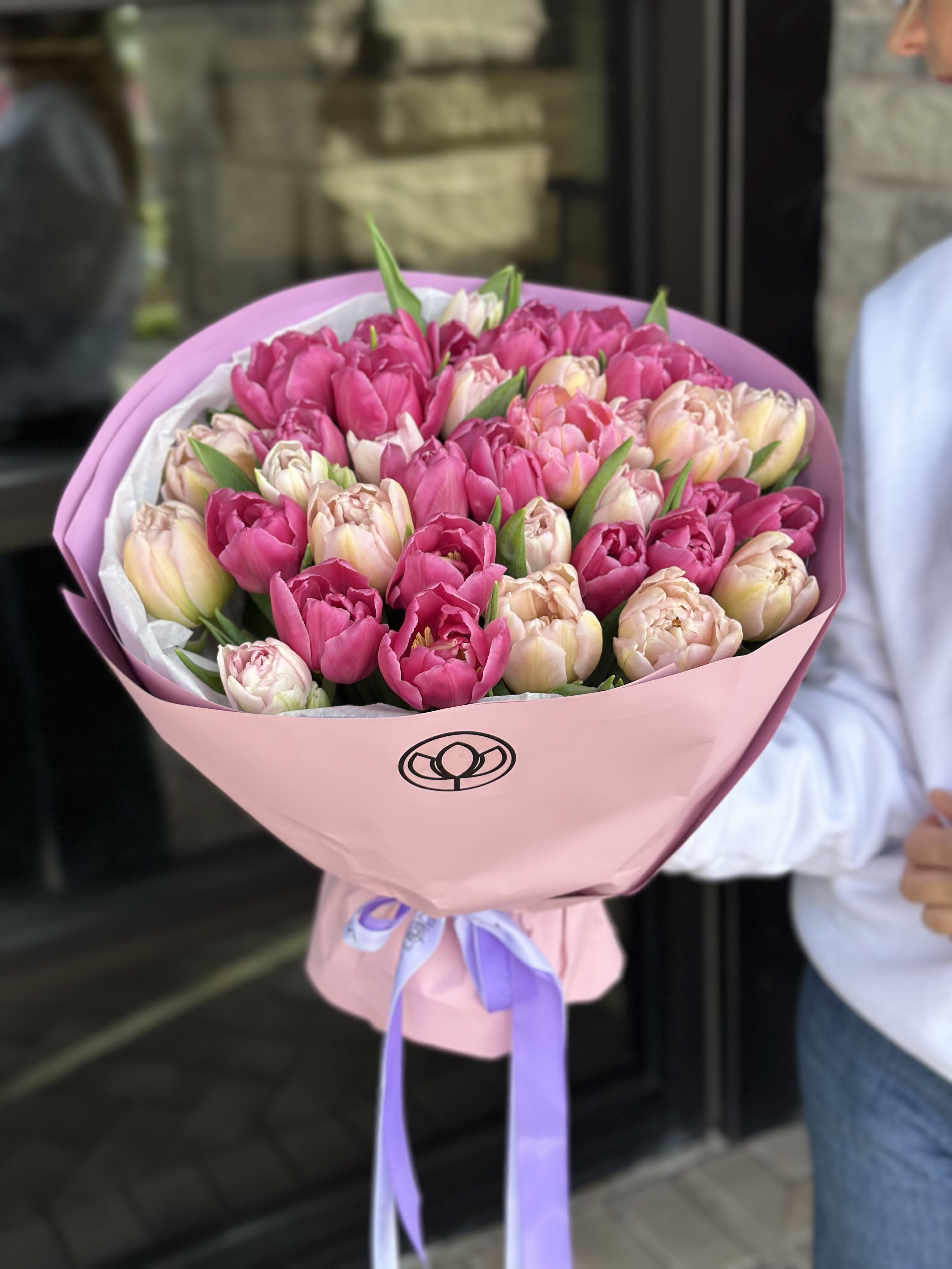 Bouquet of pink and blush tulips wrapped in pink paper
