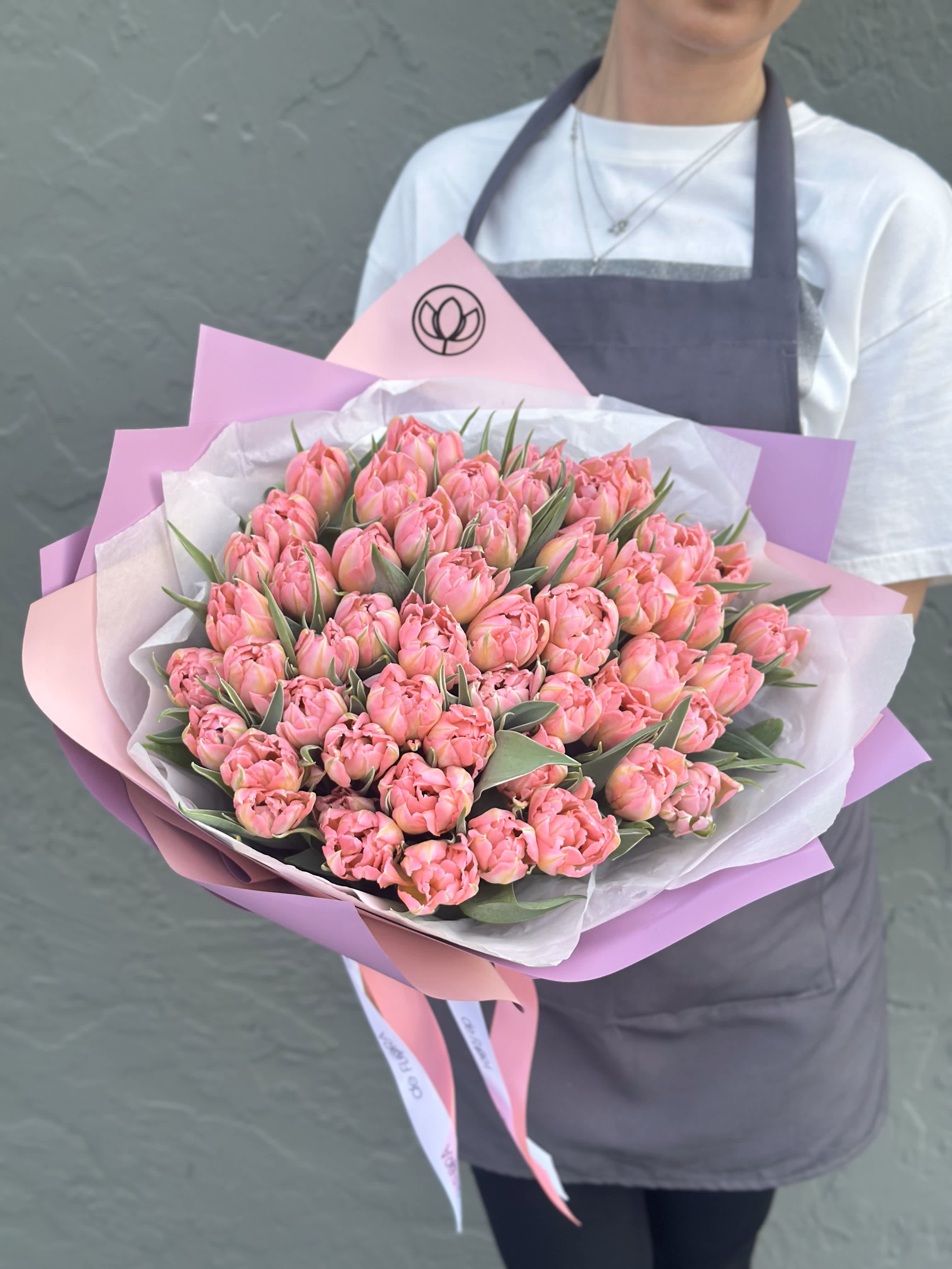 Large bouquet of pink tulips wrapped in pink and white paper