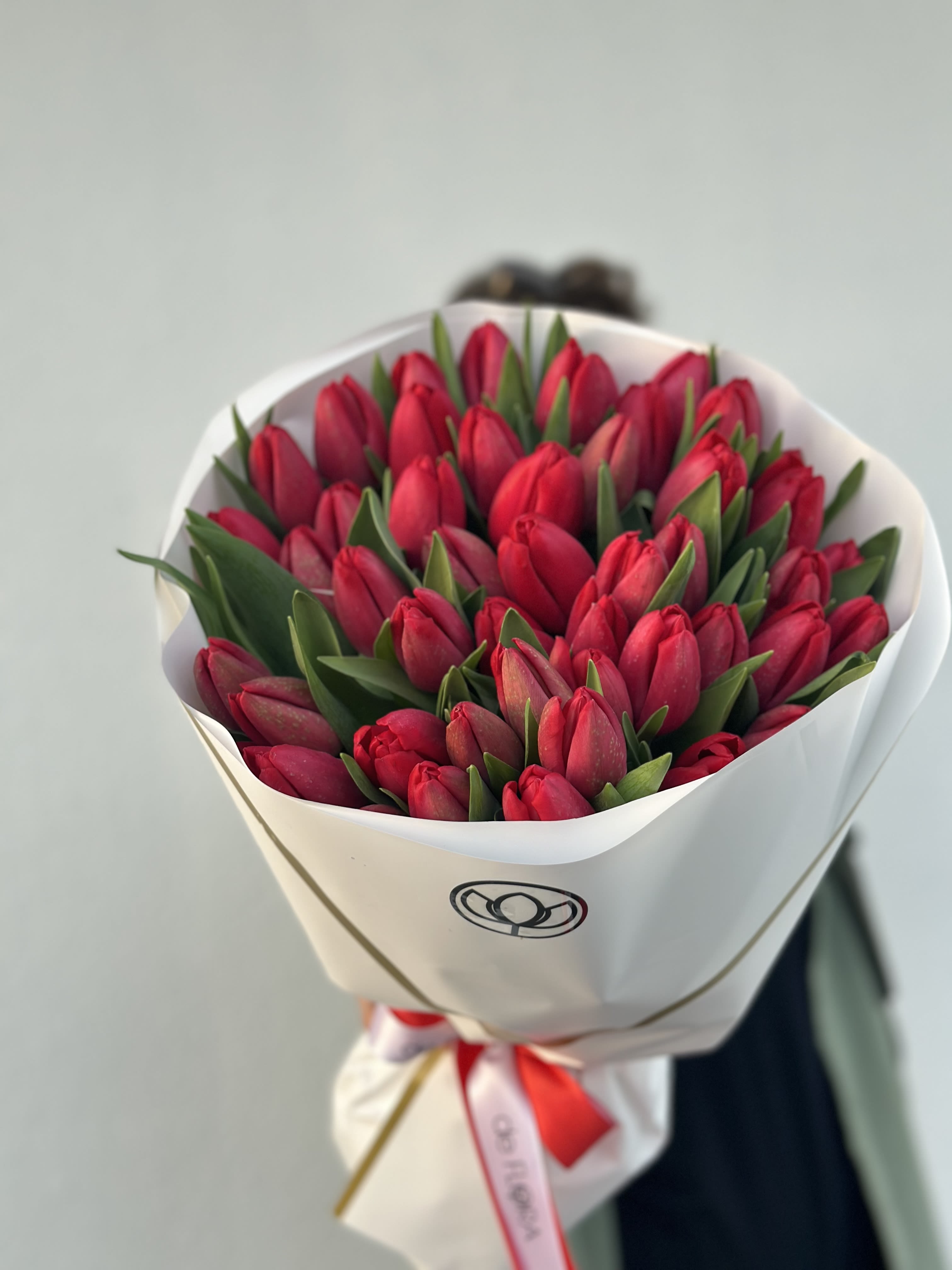 Bouquet of red tulips wrapped in white paper