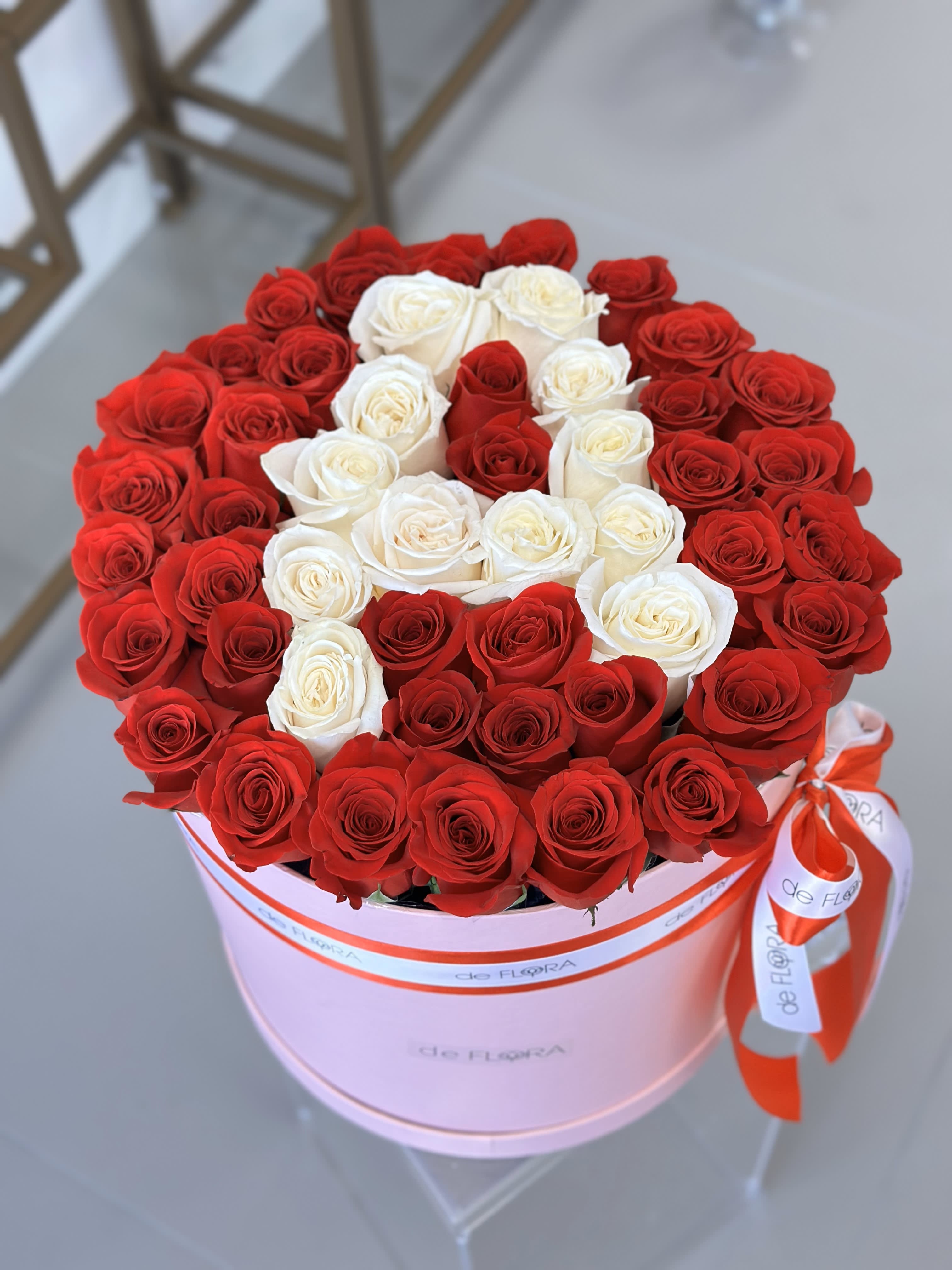 Round box of red and white roses tied with a ribbon