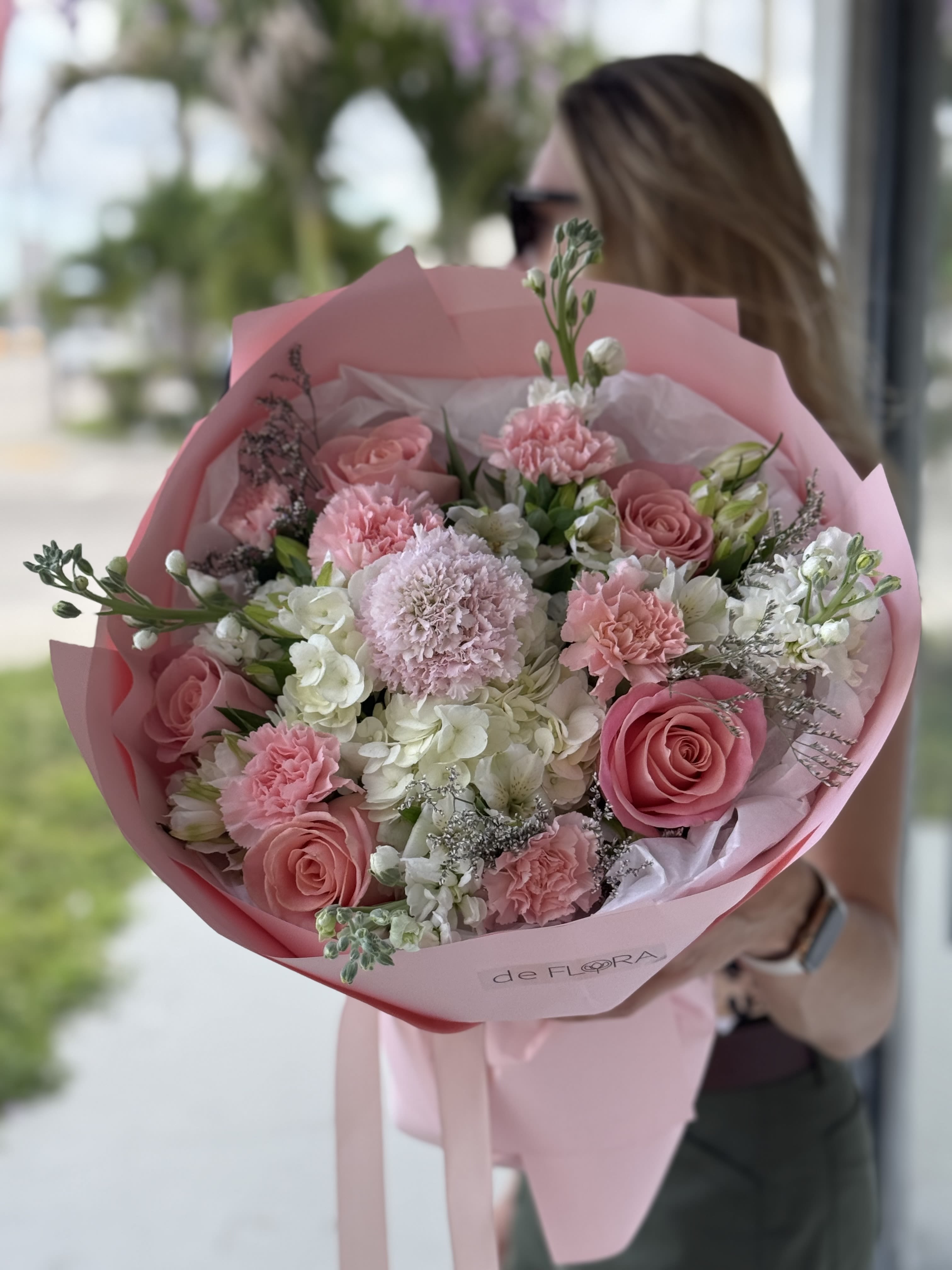 Pink rose and carnation bouquet wrapped in pink paper