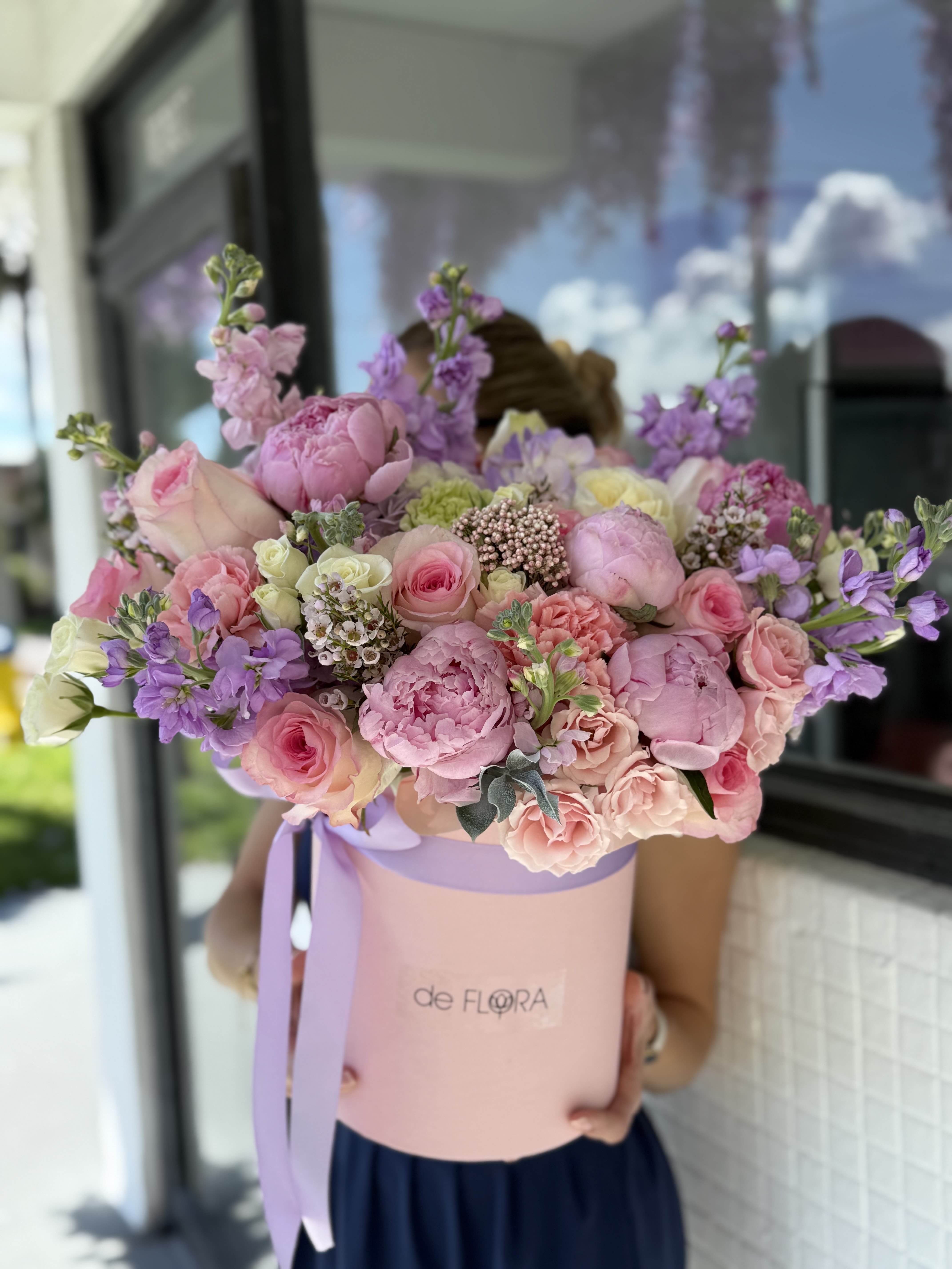 Large pastel bouquet in a pink hat box with lavender ribbon