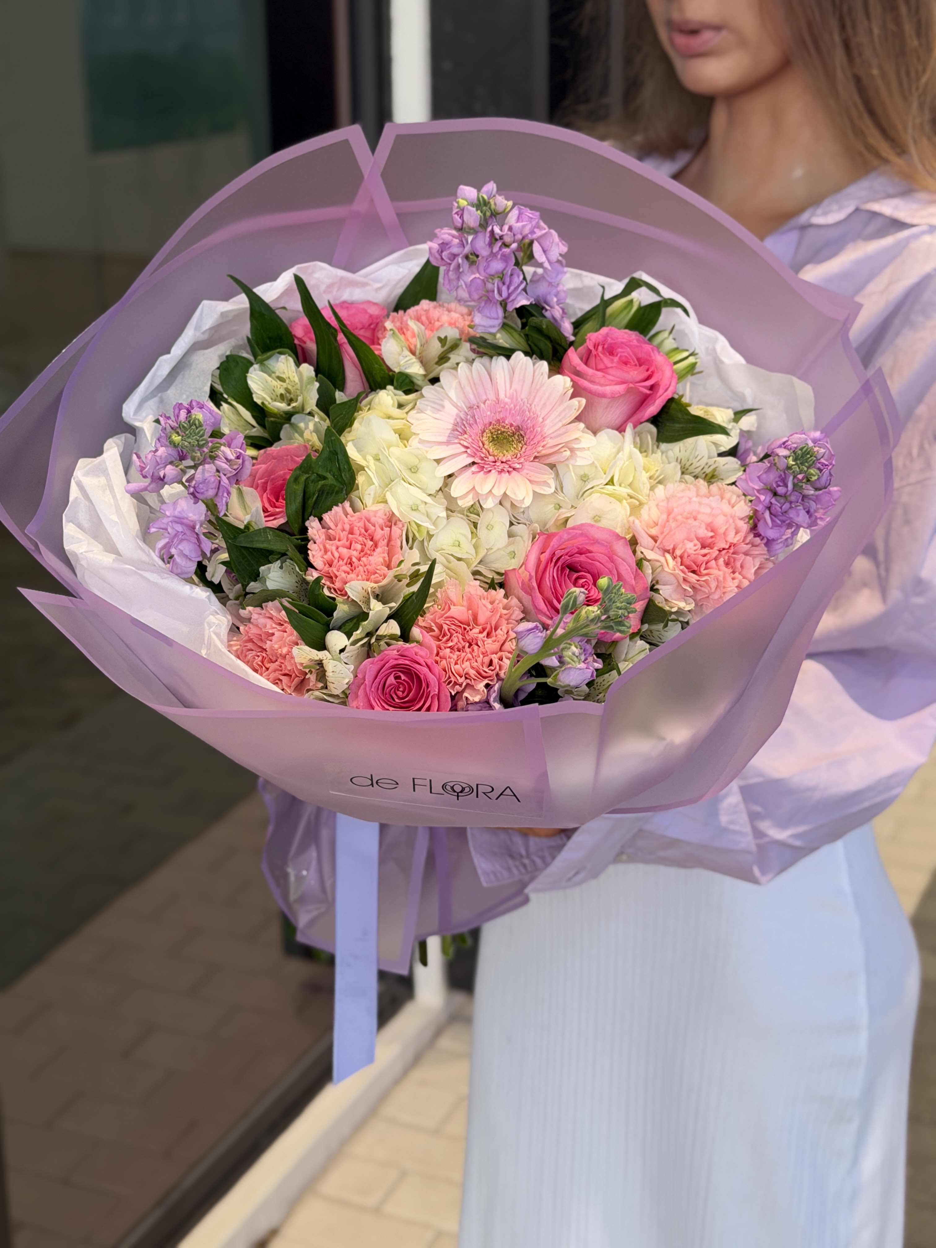 Bouquet of pink and white flowers wrapped in lavender paper
