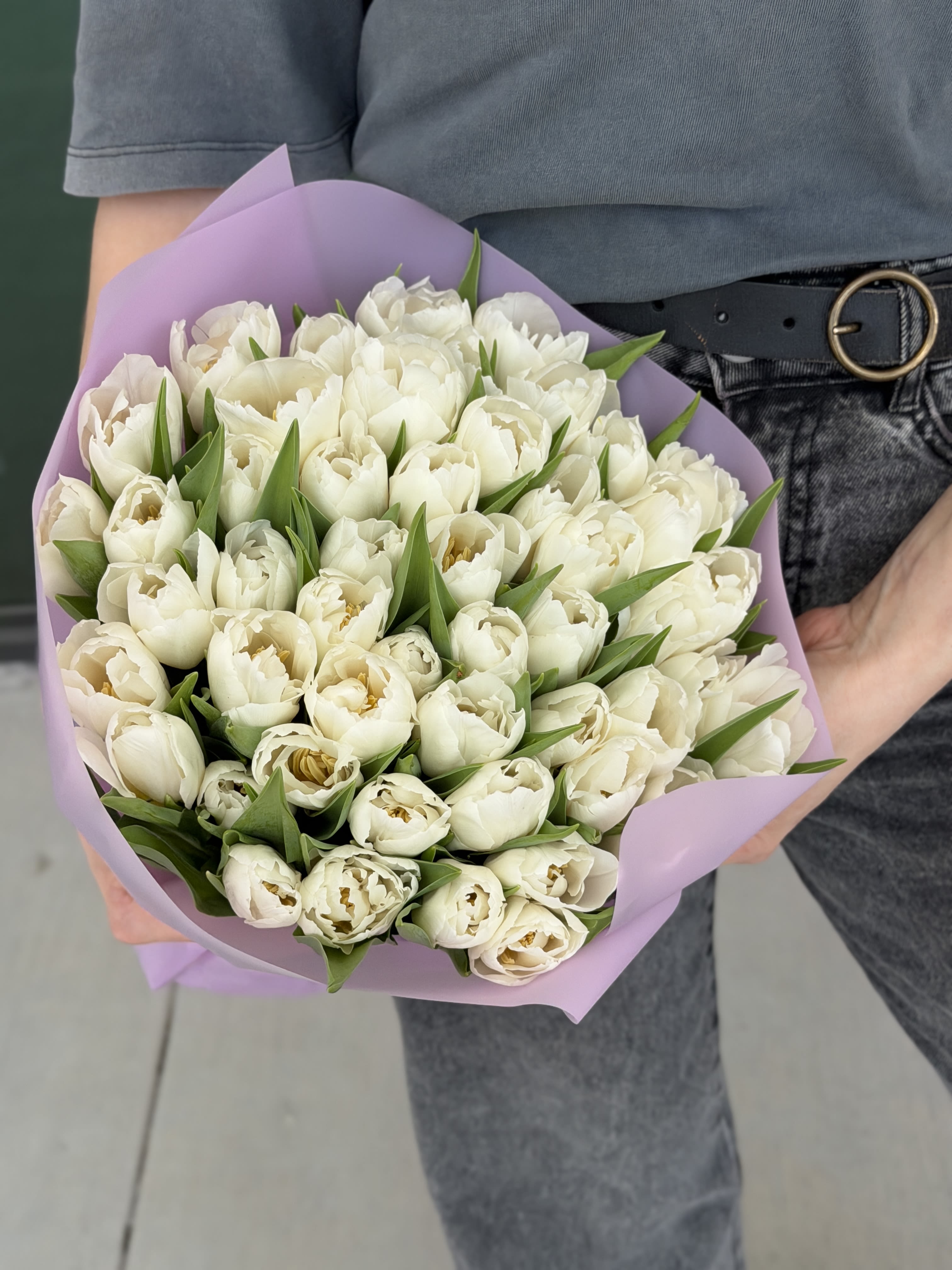 Bouquet of white tulips wrapped in lavender paper