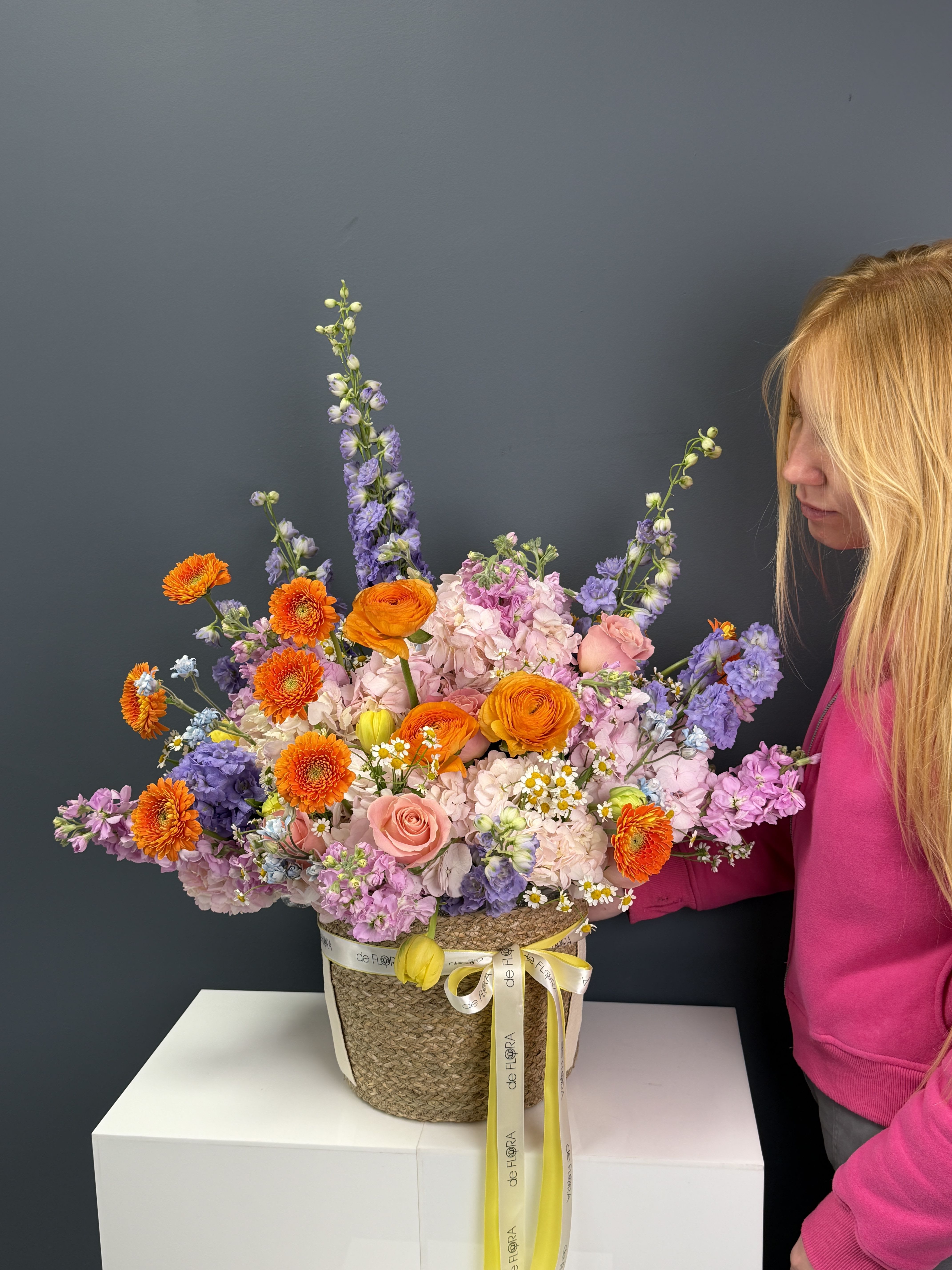 Sunset Garden Basket - A vibrant, garden-style arrangement bursting with life and color. This basket features lush pink hydrangeas, delicate blush roses, bright orange ranunculus and gerberas, and soft lavender accents, creating a perfect harmony of warmth and elegance. Designed with an airy, natural flow, it feels like a blooming sunset captured in a basket—joyful, refined, and unforgettable.