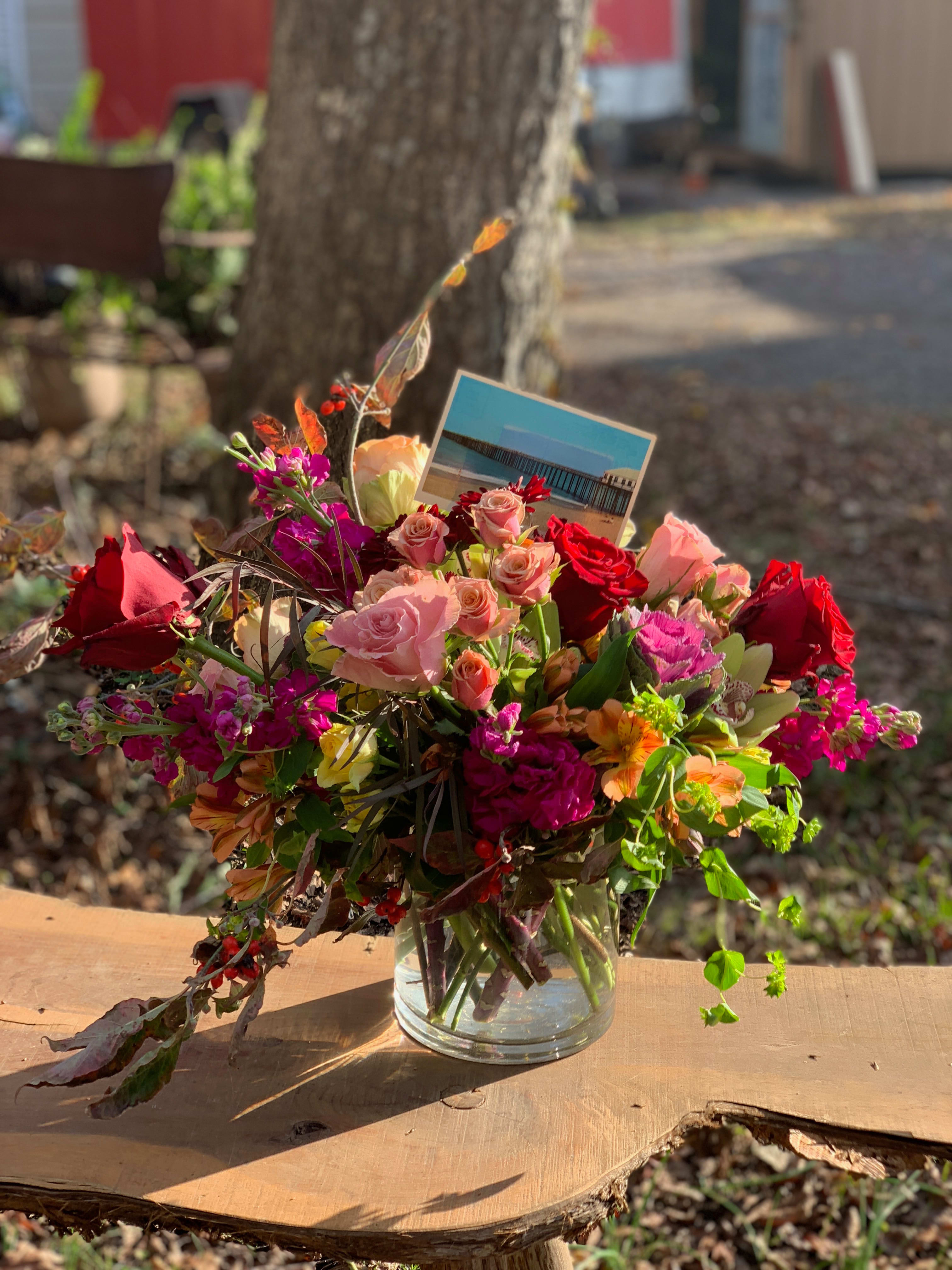 Mixed bouquet of pink and red roses in a clear glass vase