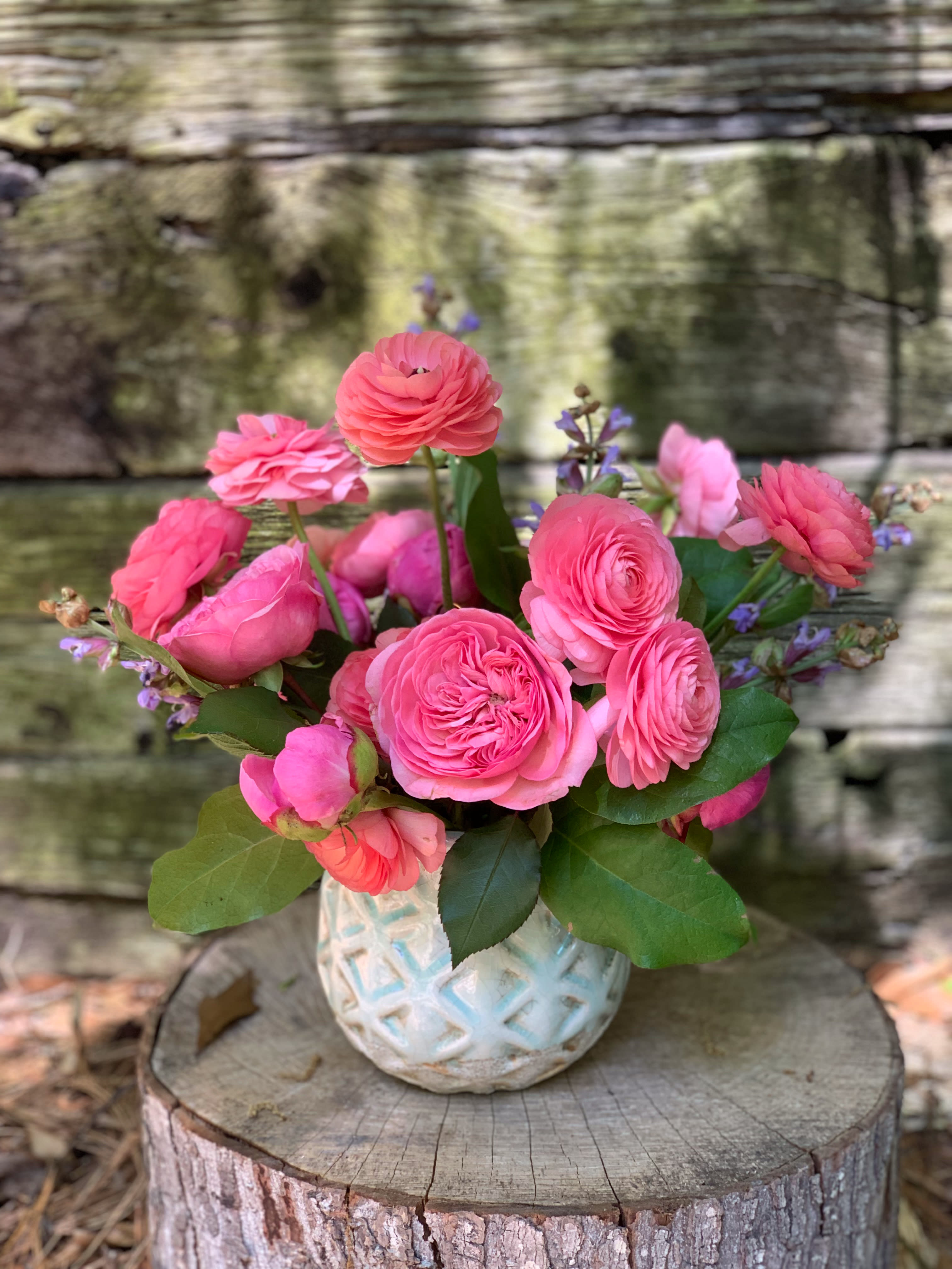 Pink ranunculus bouquet in a white textured vase