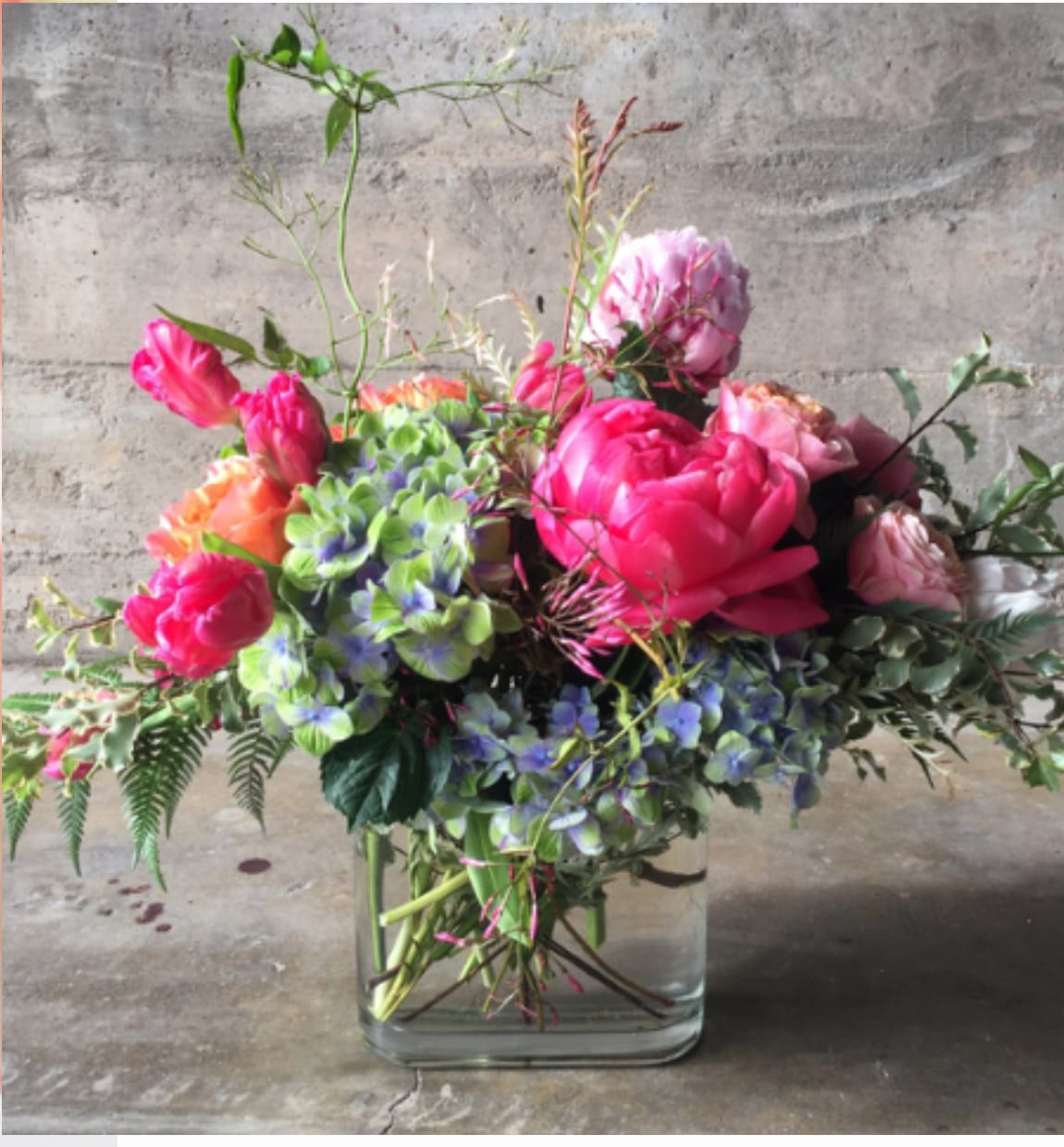 Mixed pink and purple floral arrangement in a clear glass vase