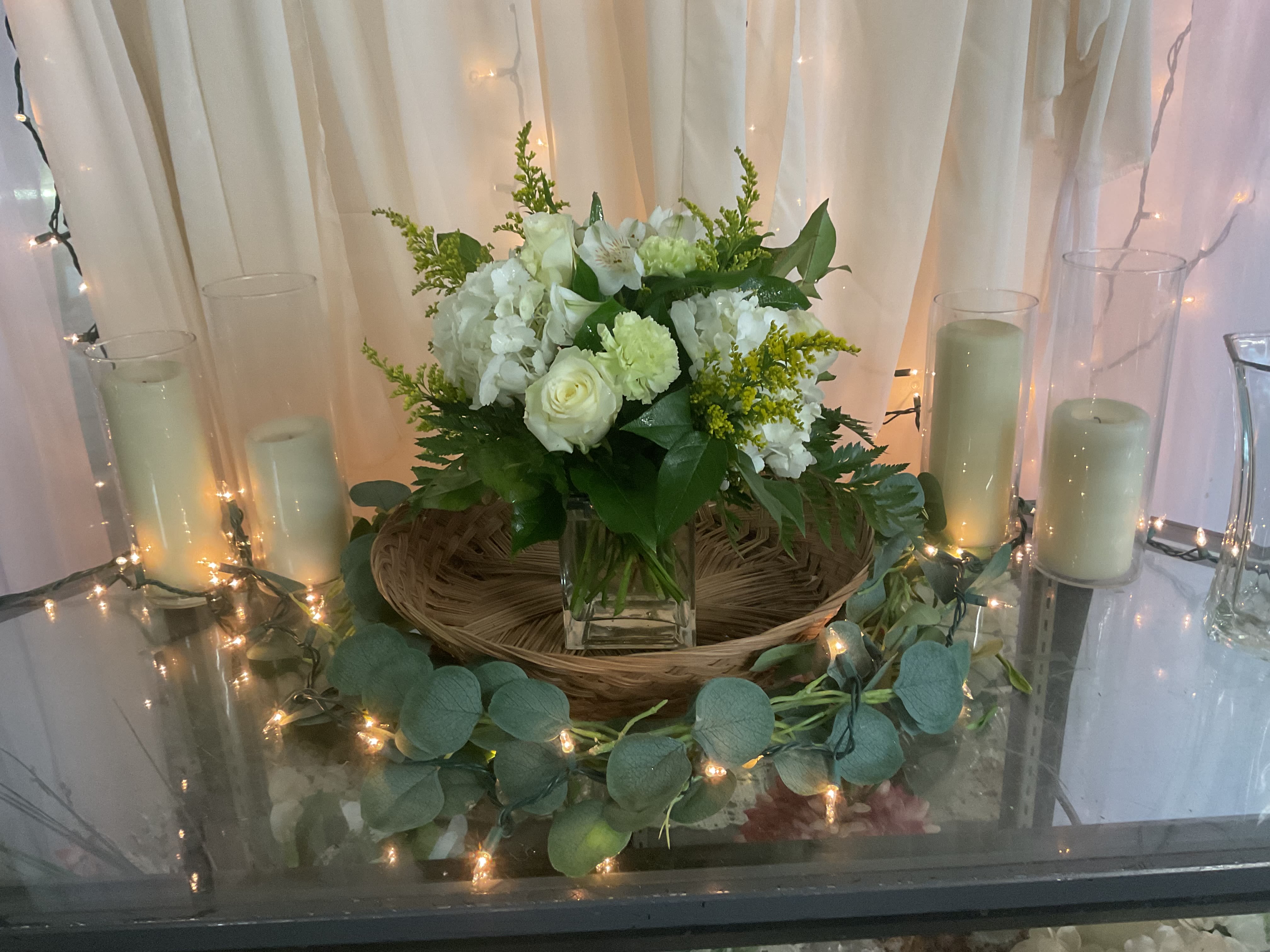 Even Flow - A dense cluster of white roses, hydrangeas, carnations and alstroemeria-softly accented with green foliage and pale yellow filler-creates a serene arrangement. 