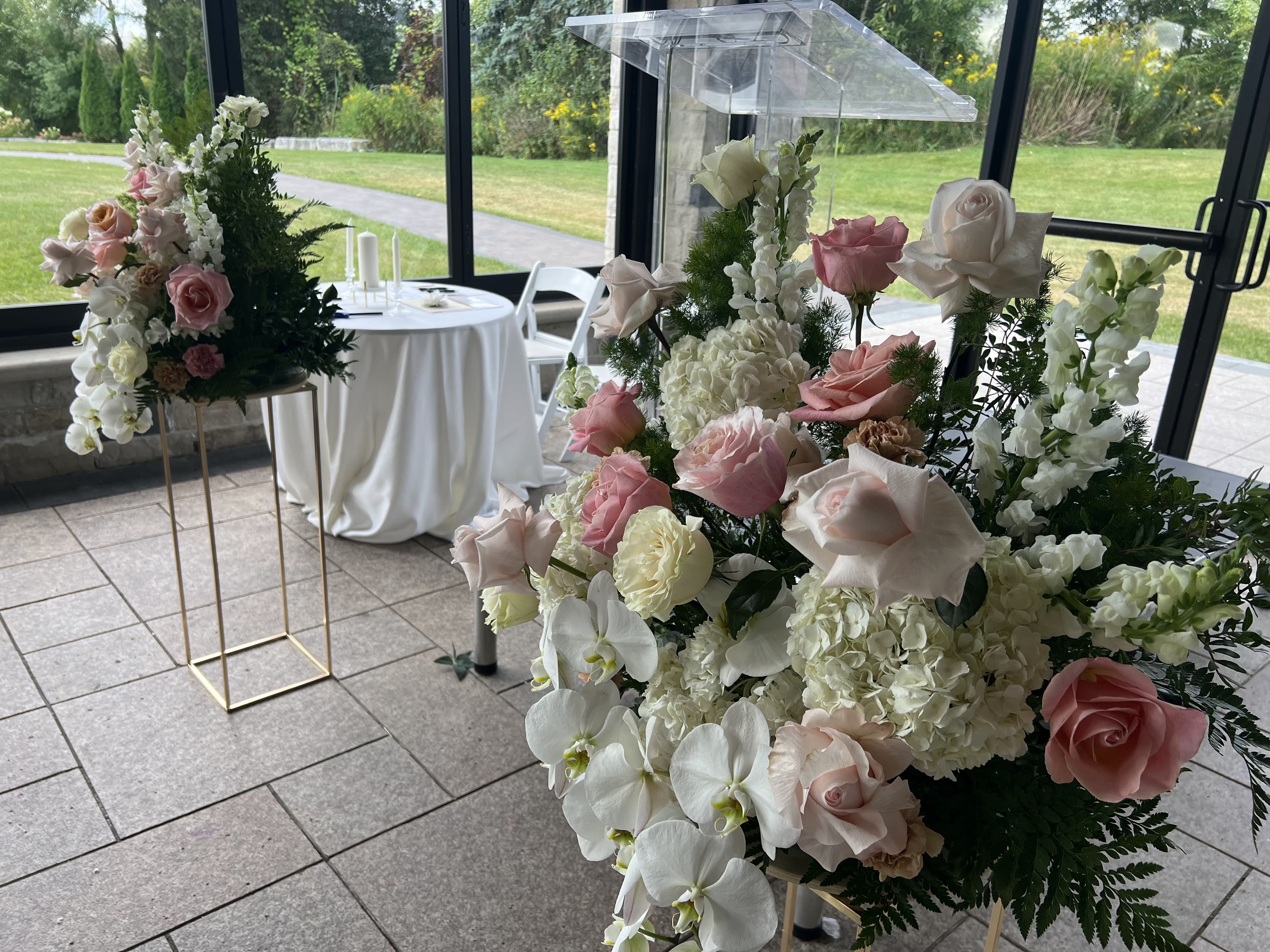 Tall wedding floral arrangement with pink and white roses and orchids