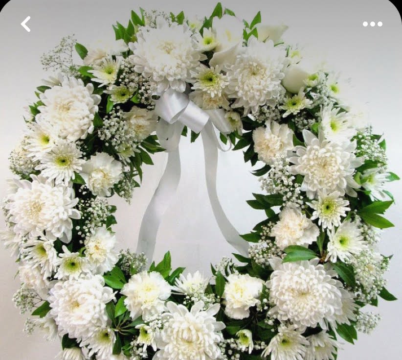 White floral wreath with a satin ribbon bow