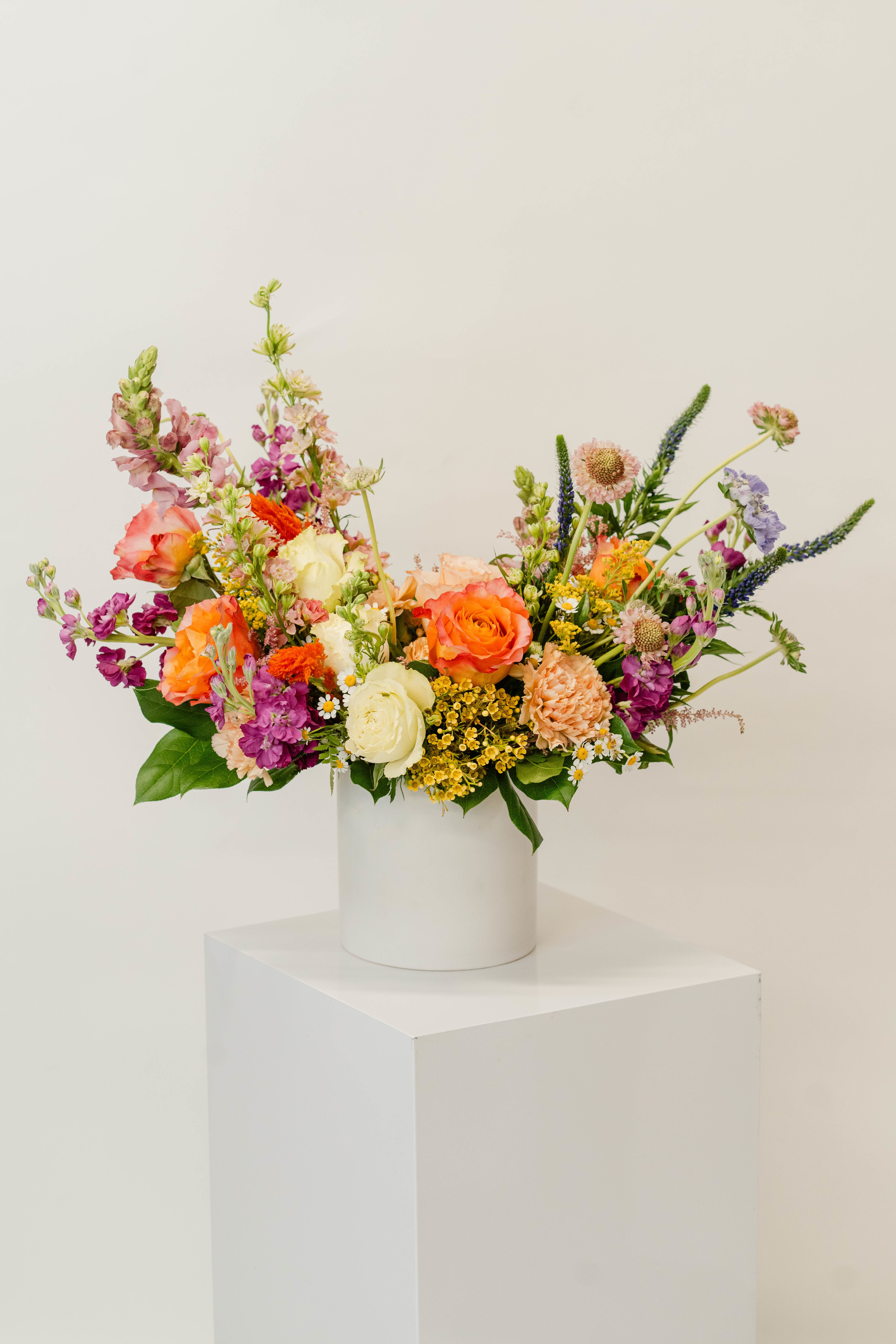 Colorful mixed bouquet in a white cylindrical vase