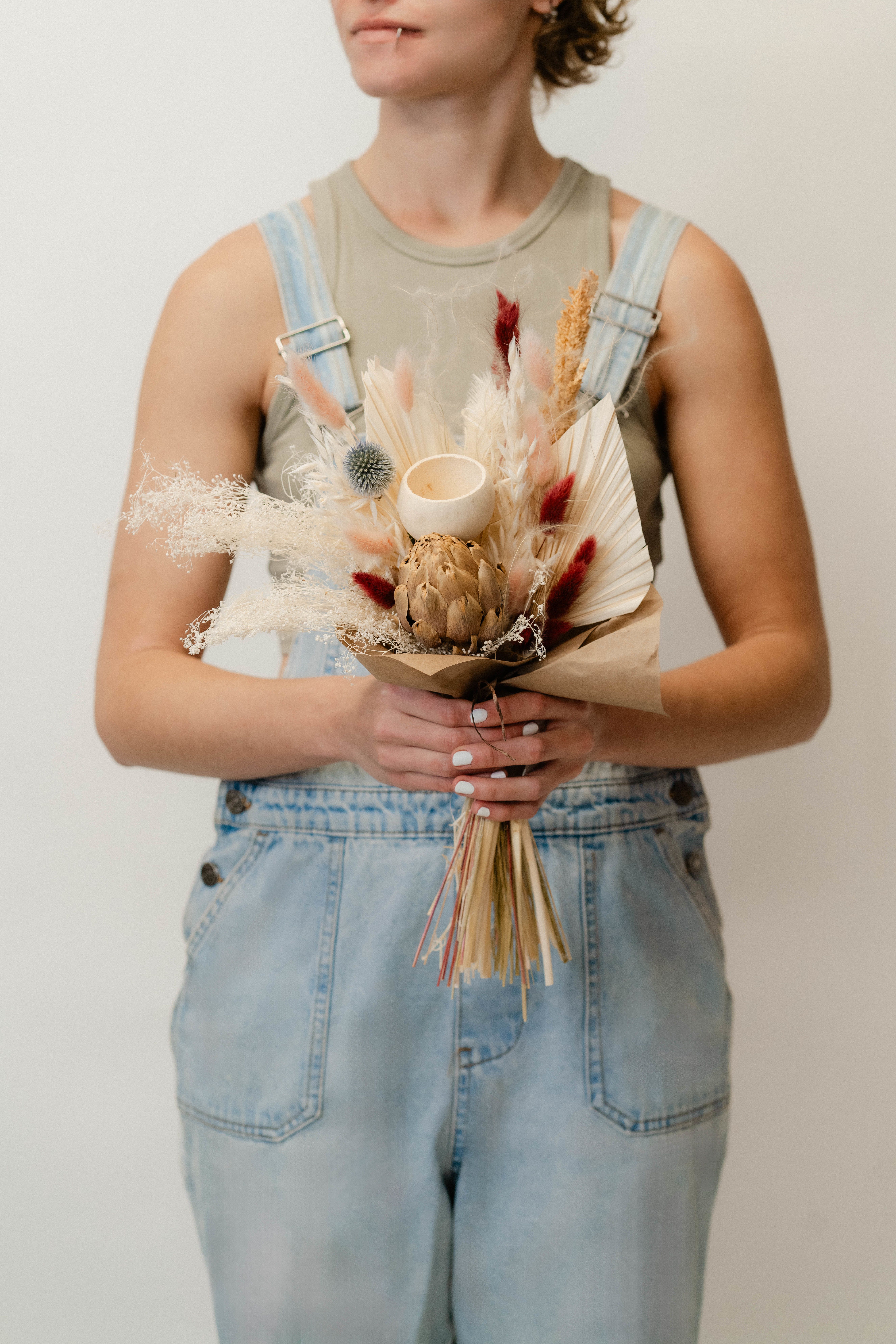 Dried bouquet with a protea, pampas grass, and a small candle