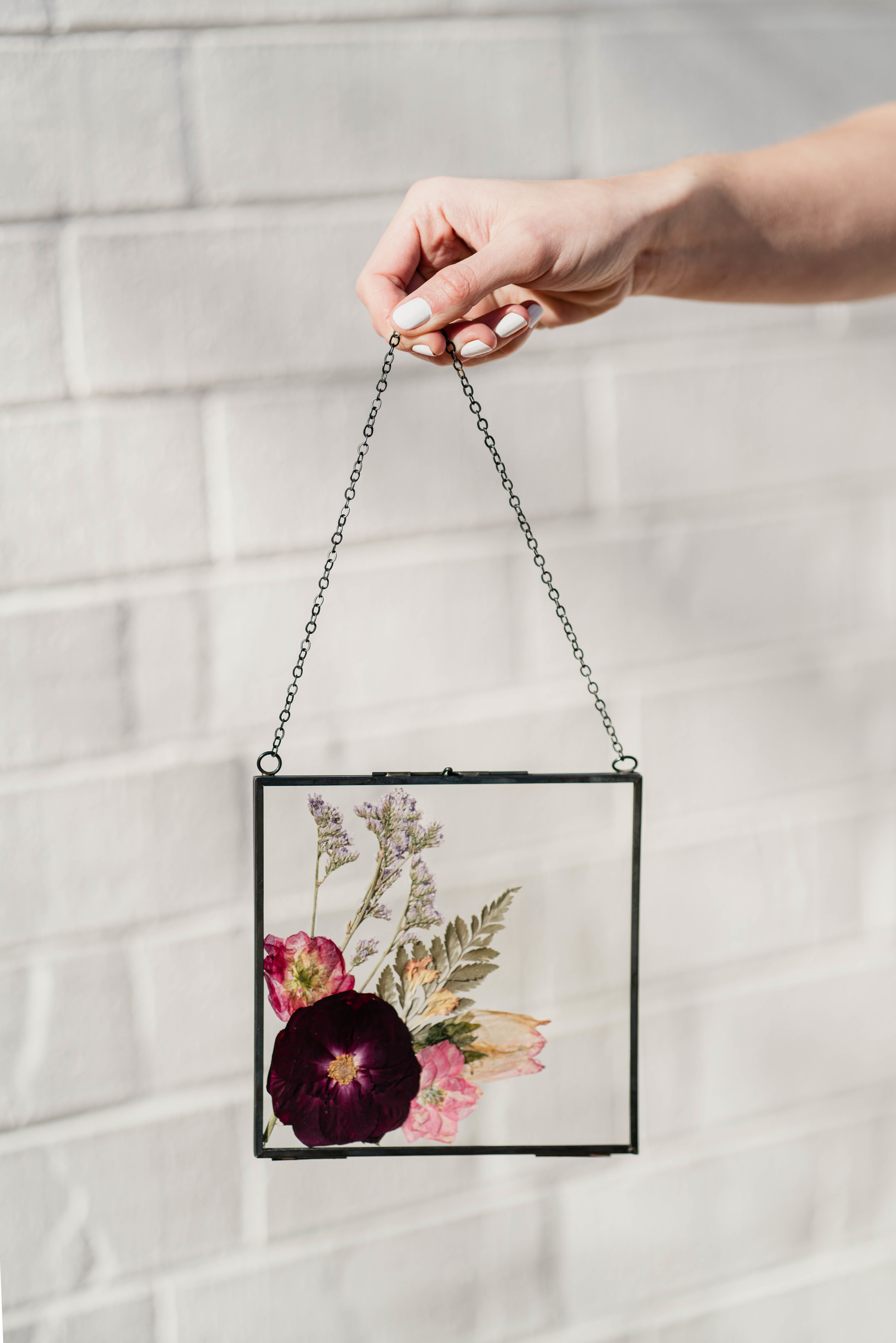 Pressed flowers in a black-framed hanging glass panel