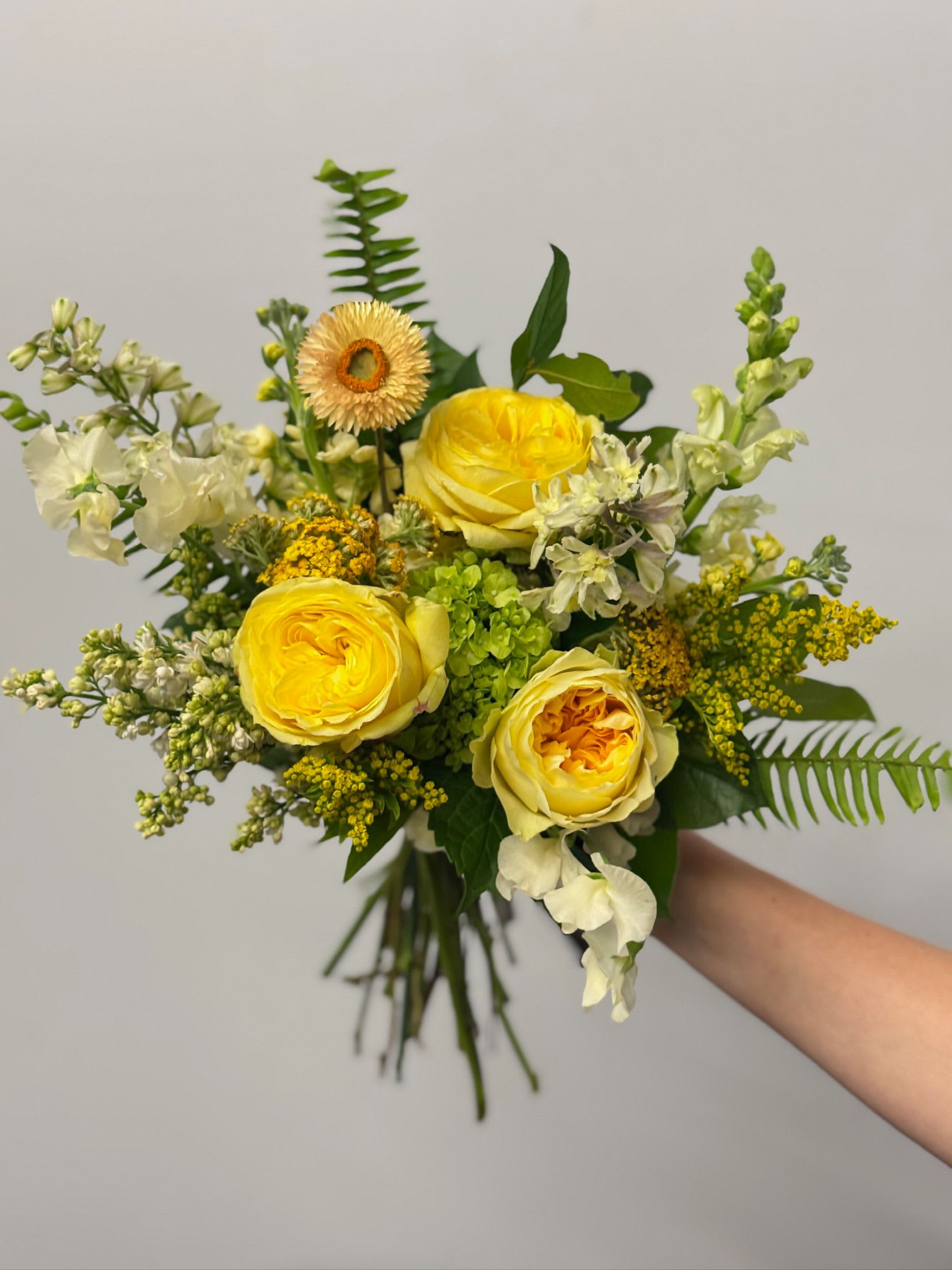 Yellow rose bouquet with white accent flowers and greenery