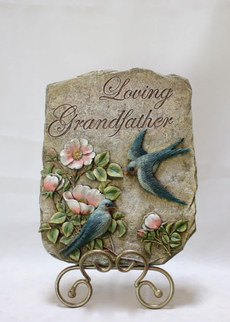 Decorative stone plaque reading "Loving Grandfather" with birds and flowers