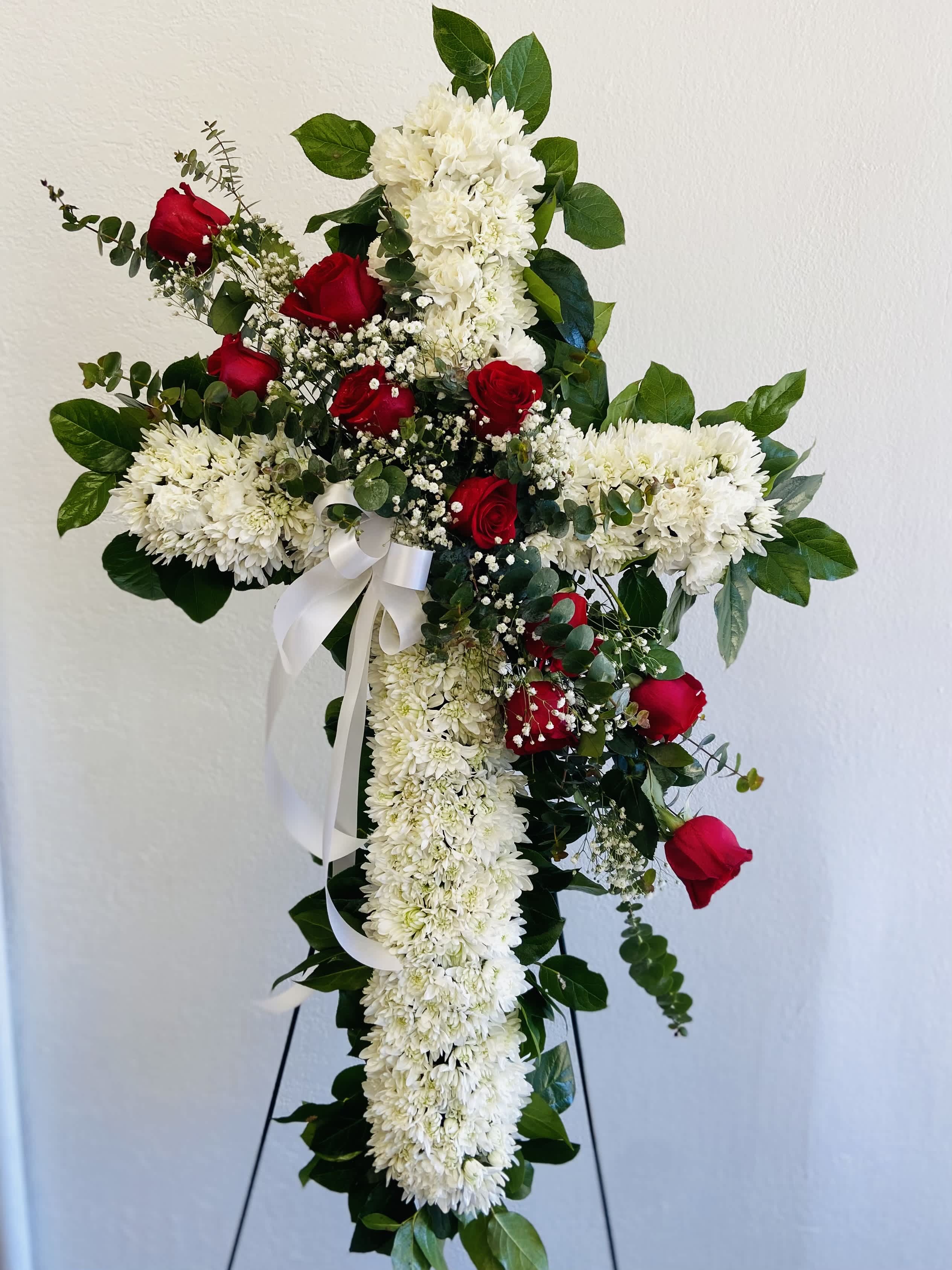 Cross-shaped floral tribute with red roses and white chrysanthemums