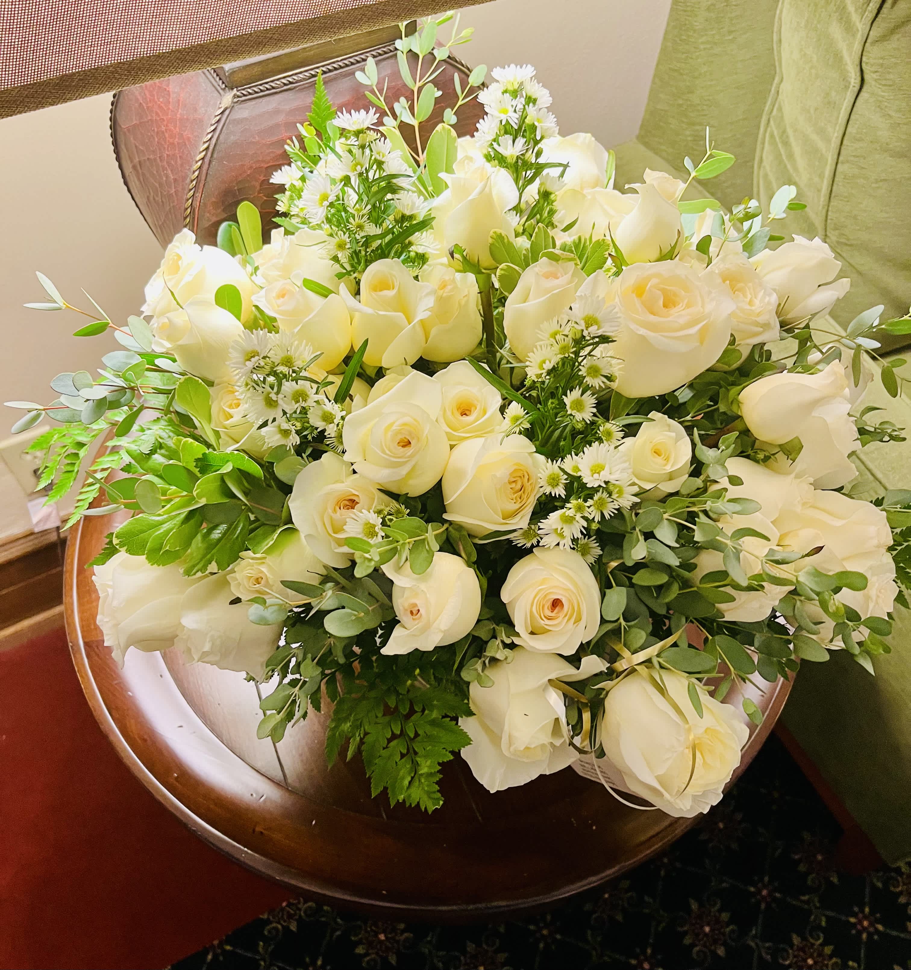 Bouquet of white roses with small white filler flowers and greenery