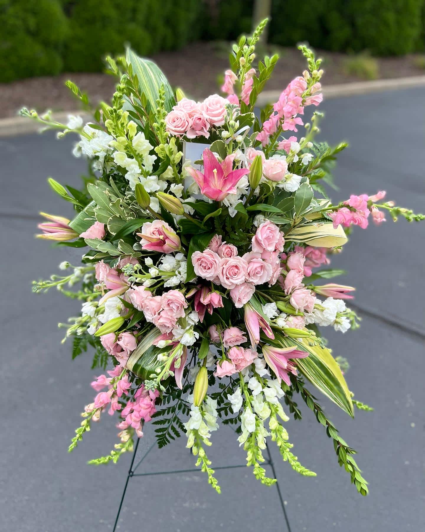 Large pink and white floral standing spray on an easel