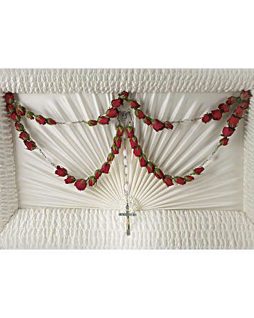 White casket spray with red rose garland and a small cross