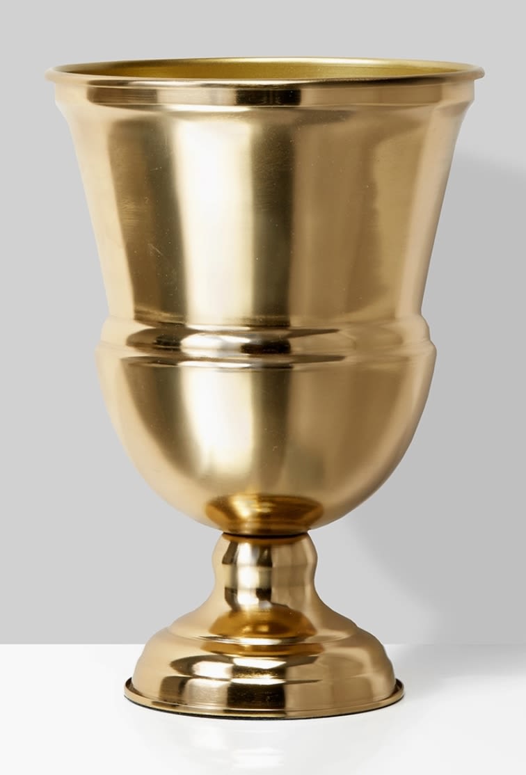 Gold metal urn vase on a plain background