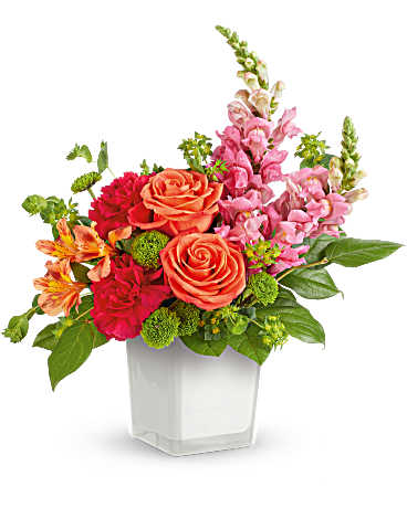 Colorful bouquet of roses, snapdragons, and pink flowers in a white vase