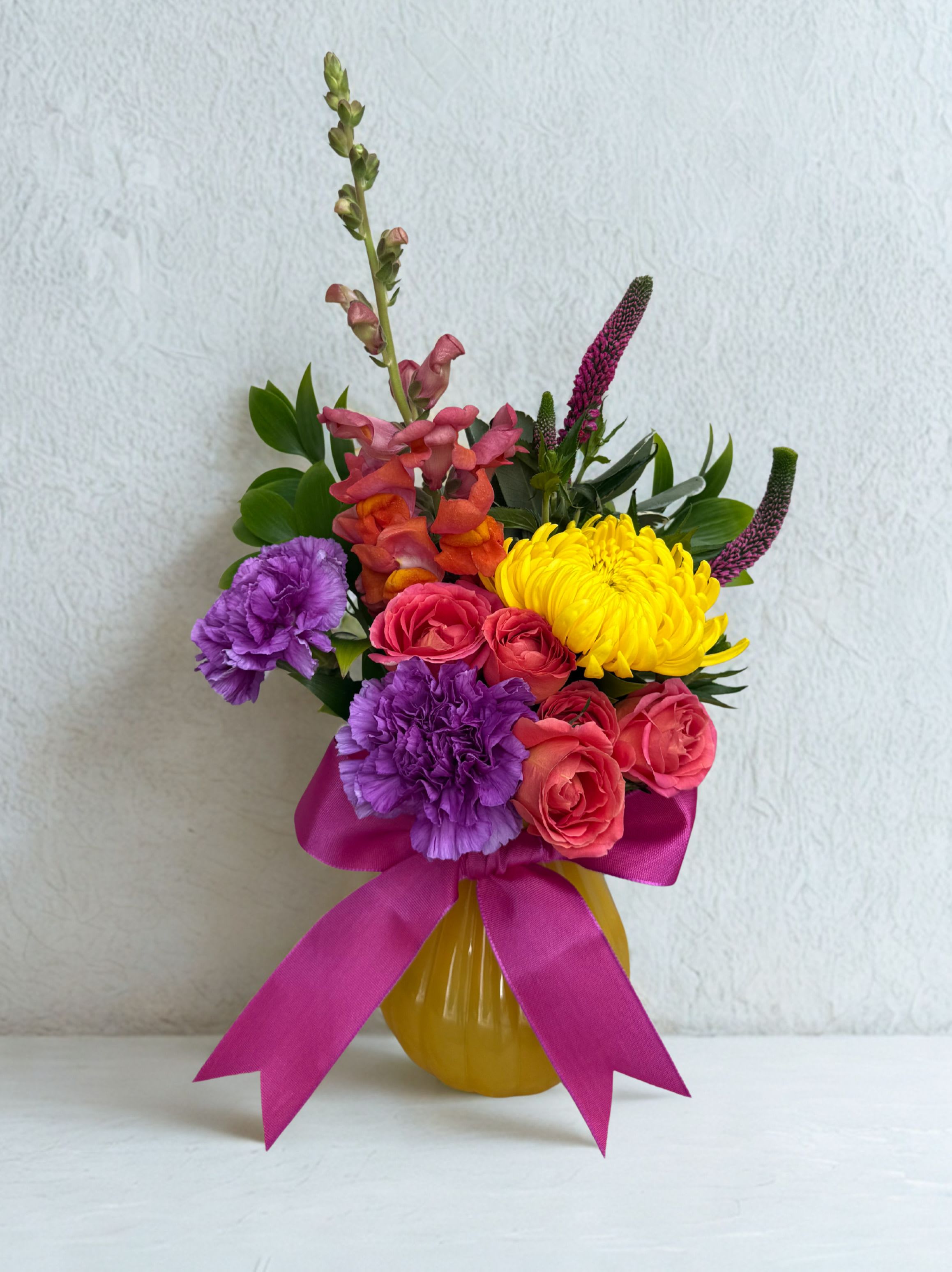 Sunshine Kiss - Bright, joyful &amp; full of personality, this arrangement brings a burst of color to any space. Spray roses, carnations, mums, snaps dragons accented with veronica. 