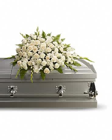 White floral spray on top of a gray casket