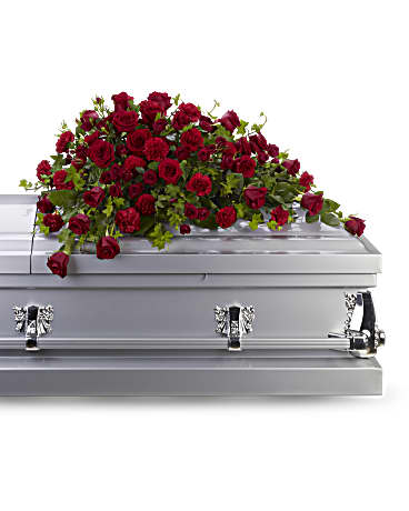 Red rose spray on top of a silver casket