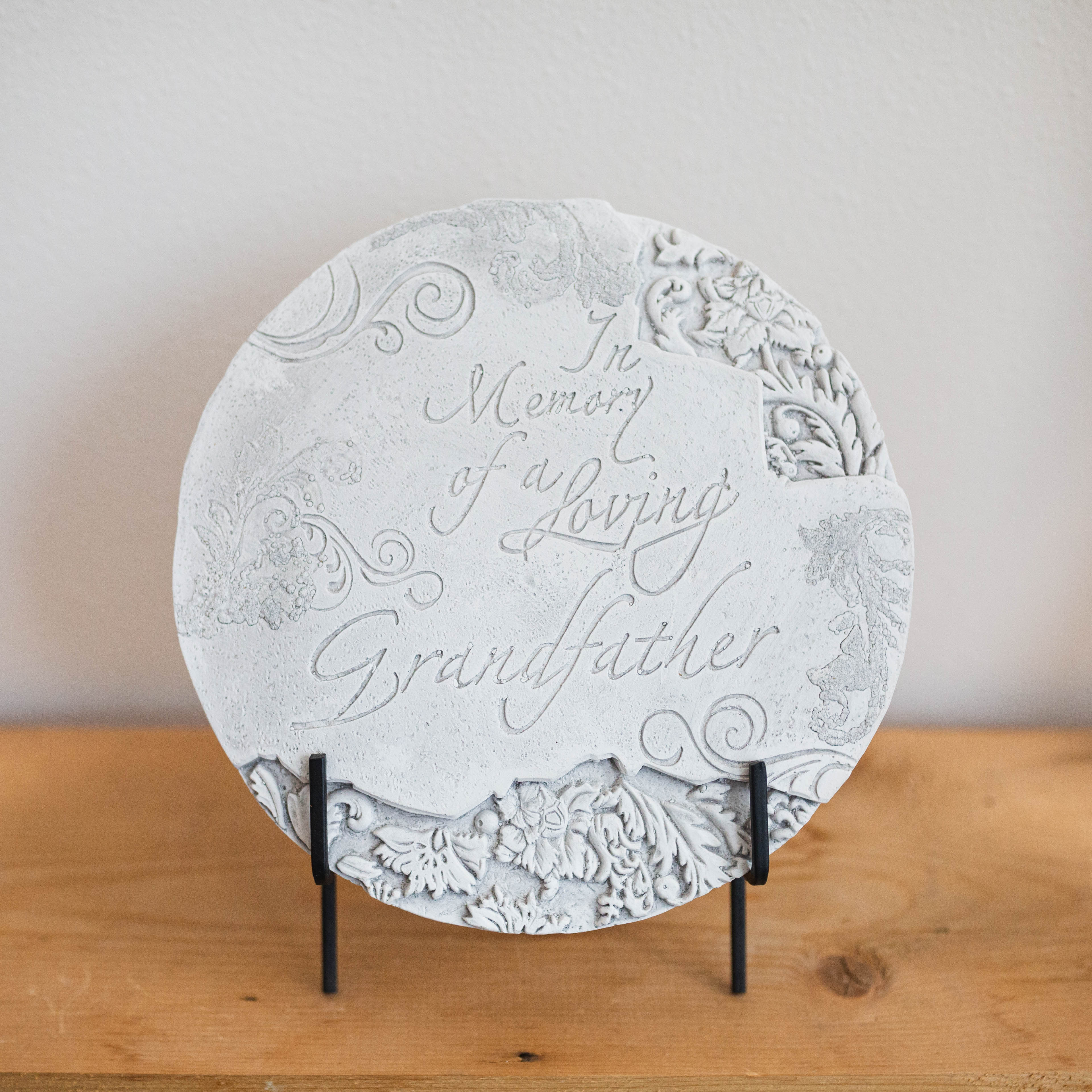 Round memorial plaque on a stand with engraved floral details