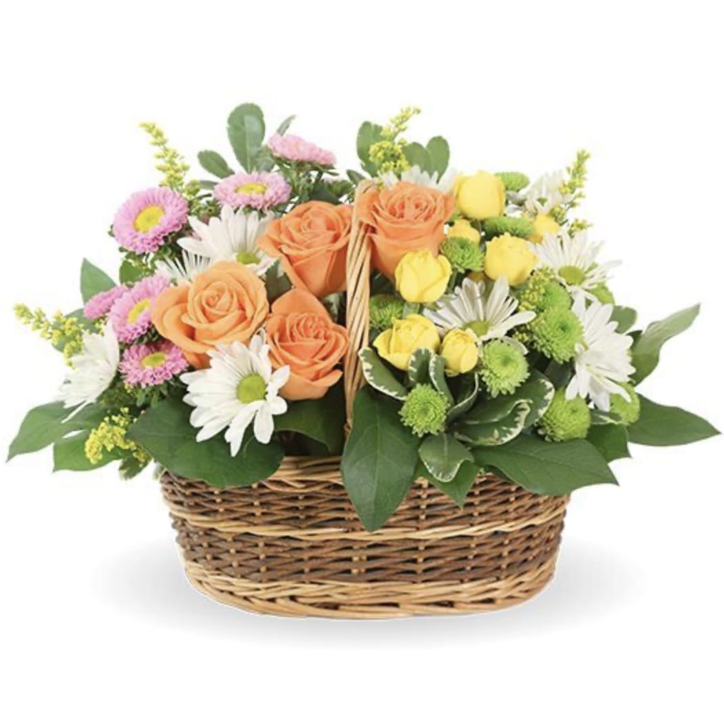 Mixed bouquet of roses, daisies, and mums in a wicker basket