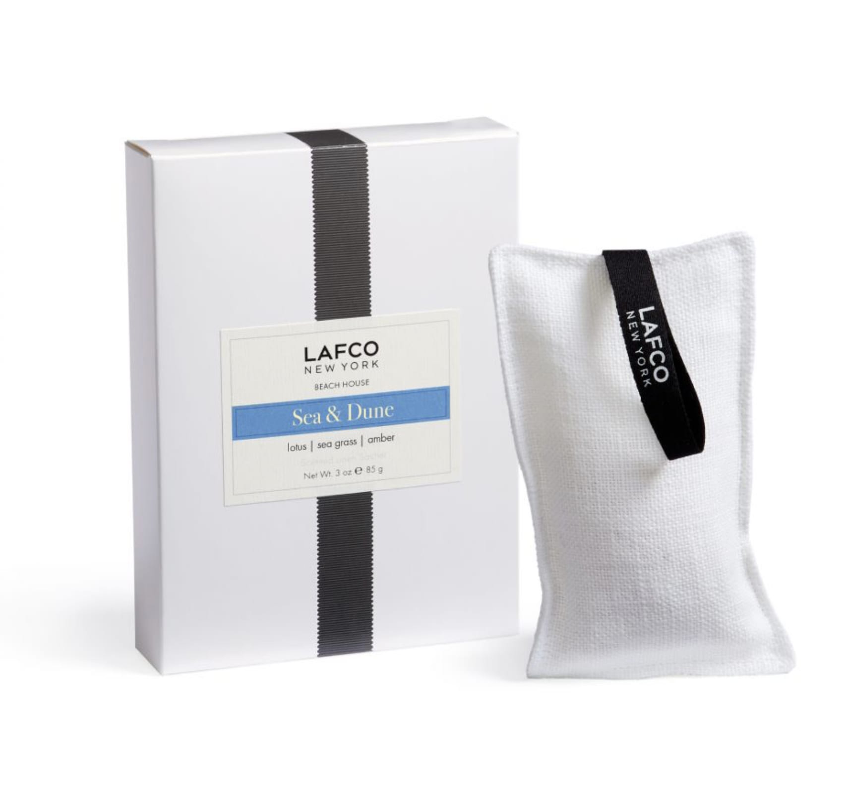 White boxed candle with a fabric sachet beside it