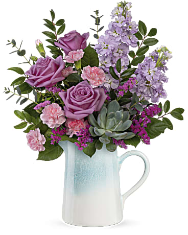 Farmhouse Chic - Sweeten Mom's special day with this stunning, ombre-glaze stoneware pitcher, bursting with country-inspired lavender and pink flowers. Lavender roses, lavender stock, miniature pink carnations, raspberry sinuata statice and a potted echeveria succulent are arranged with parvifolia eucalyptus and huckleberry.  Orientation: All-Around