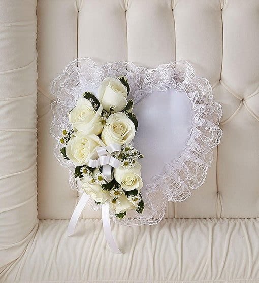 Heart-shaped white lace pillow with white roses and small daisies on one side