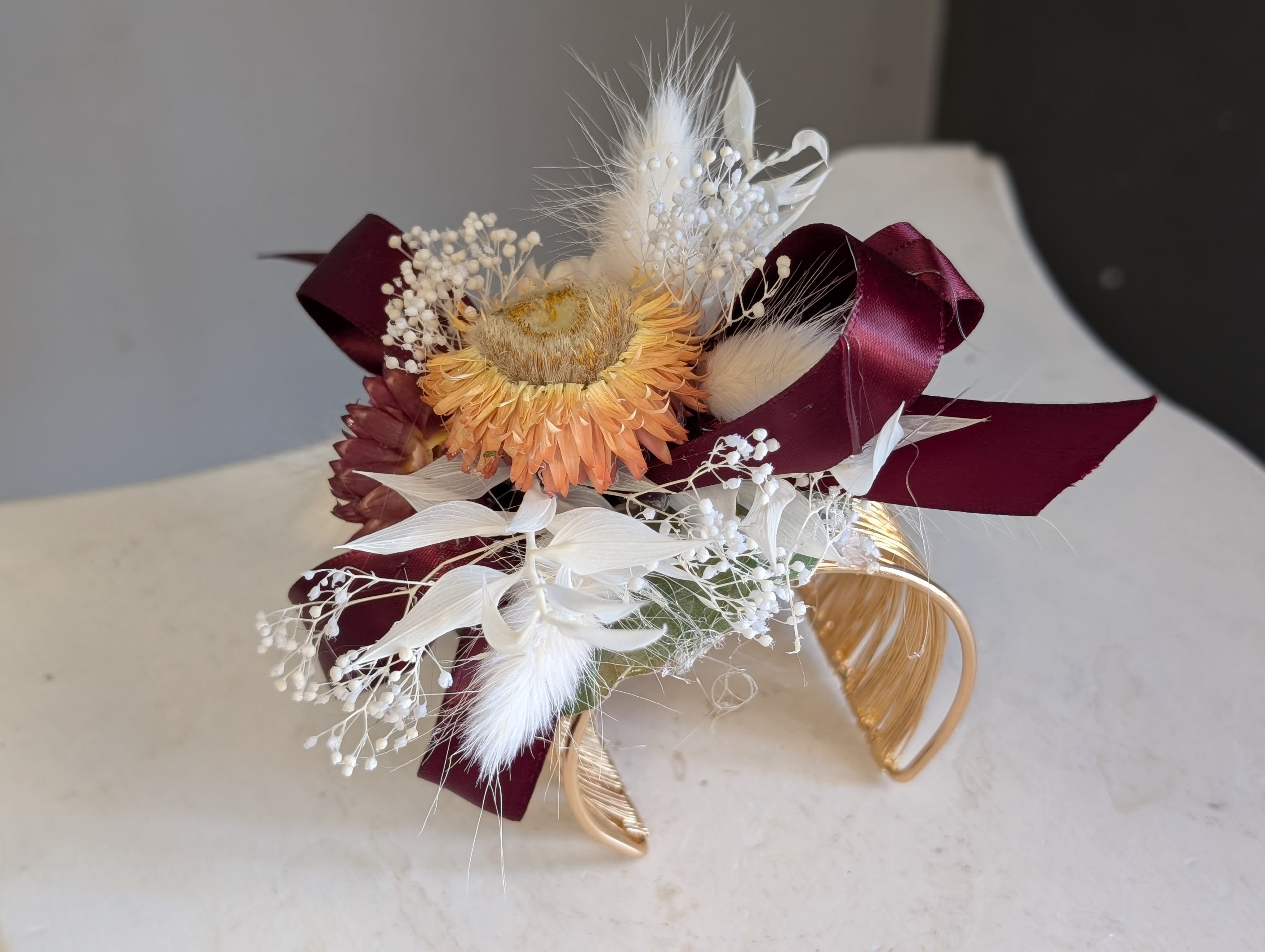 Gold corsage cuff.  - Bleach baby's breath and ruscus dressed up with bunny tails and peach straw flower taking center stage. 