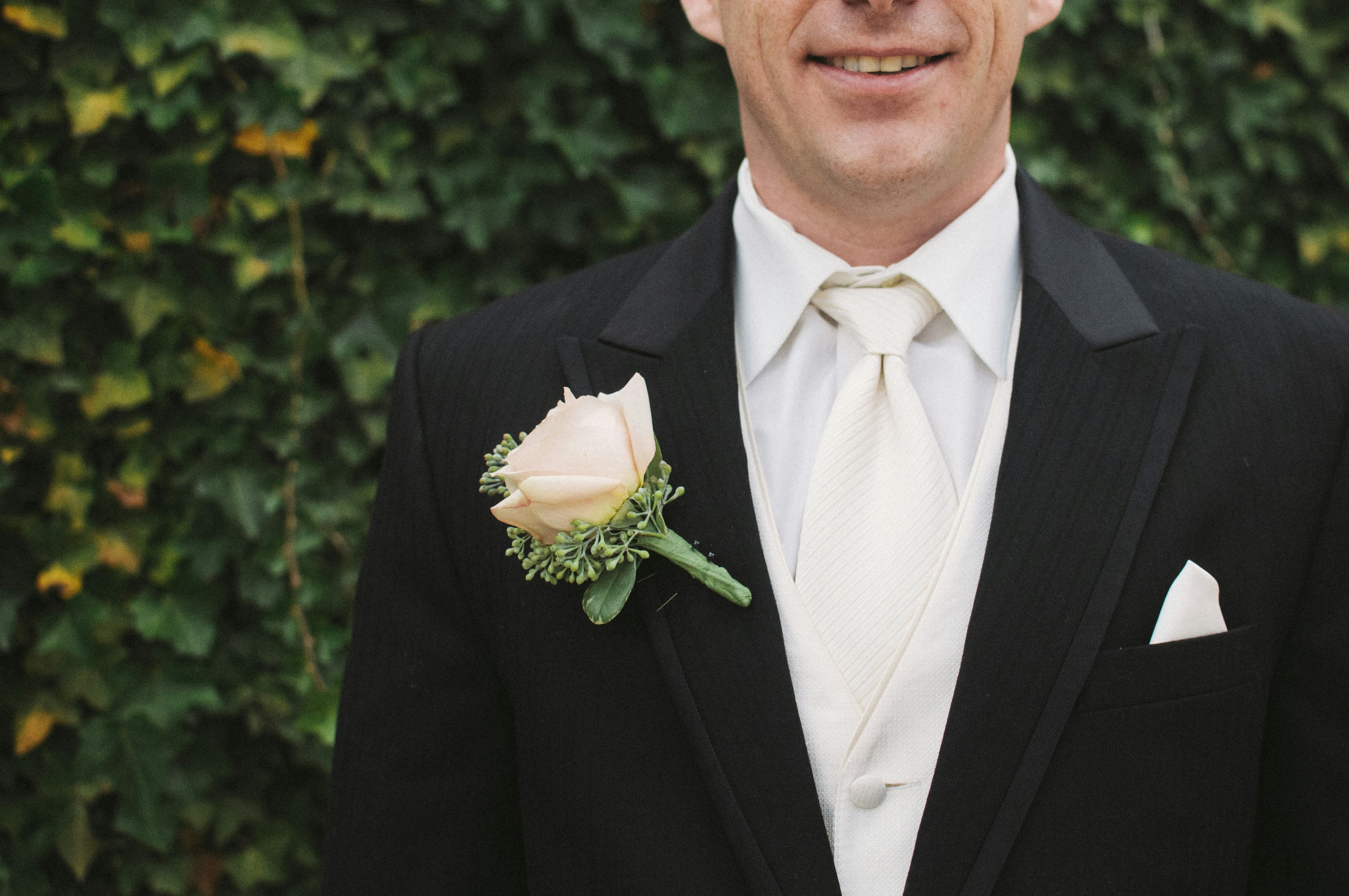 Man in a suit wearing a pale rose boutonniere